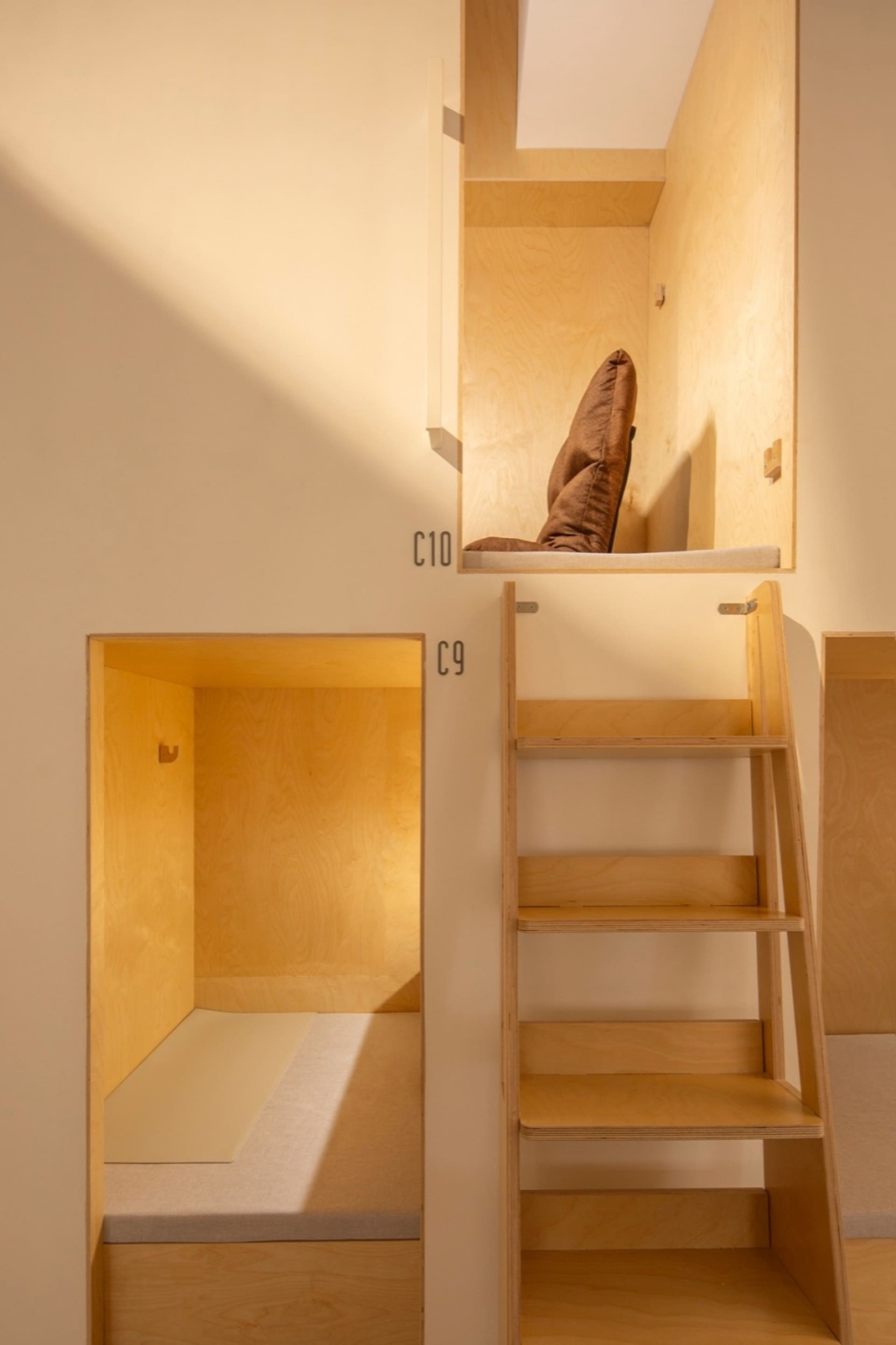 Modern industrial living space with wooden bunk beds and storage.