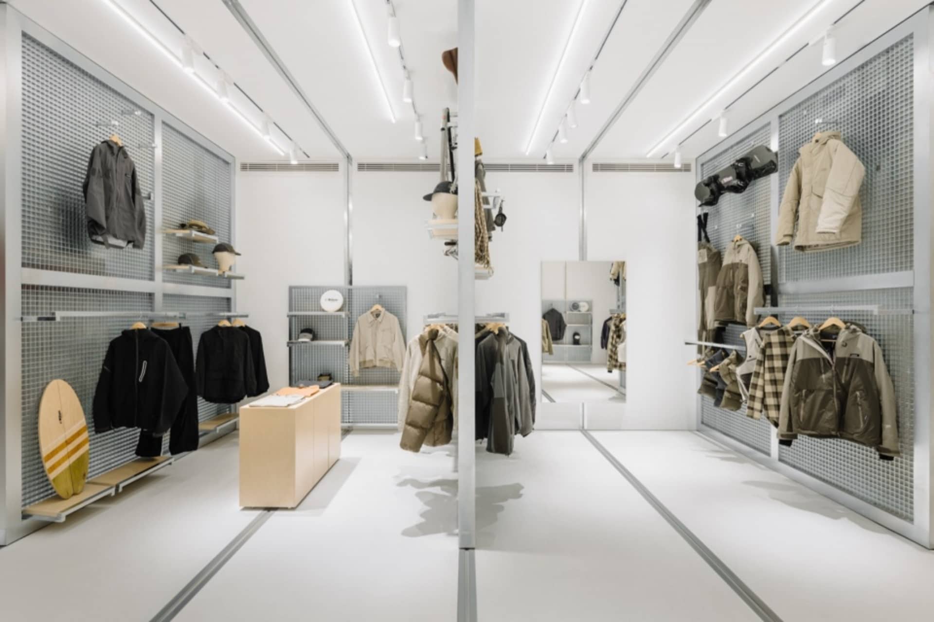 現代零售空間內的金屬展示架，陳列服裝商品。