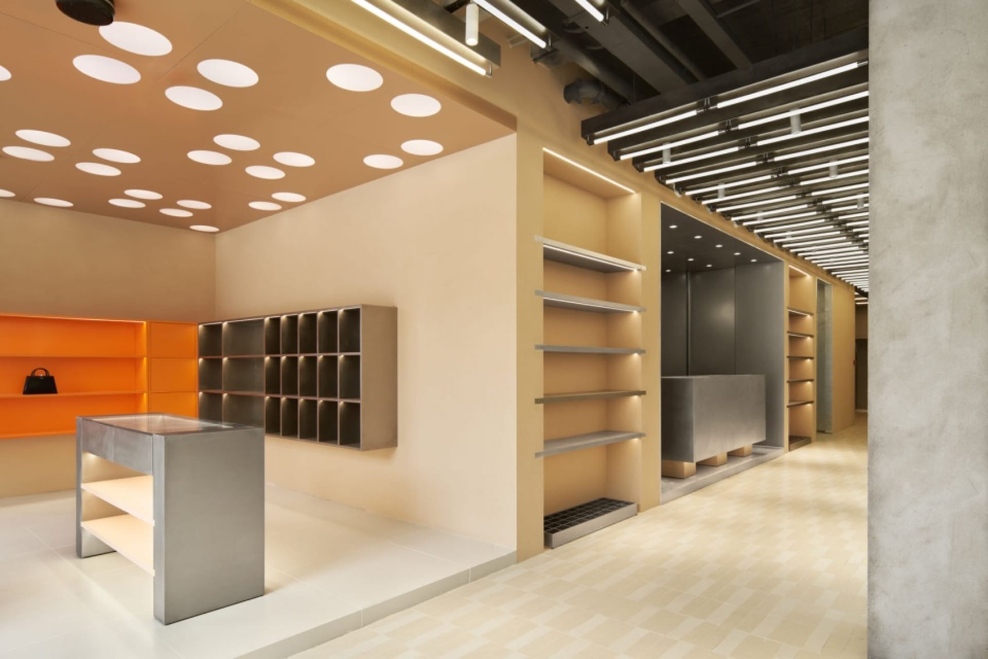 Modern retail storefront with metal shelves and orange accents on the ceiling