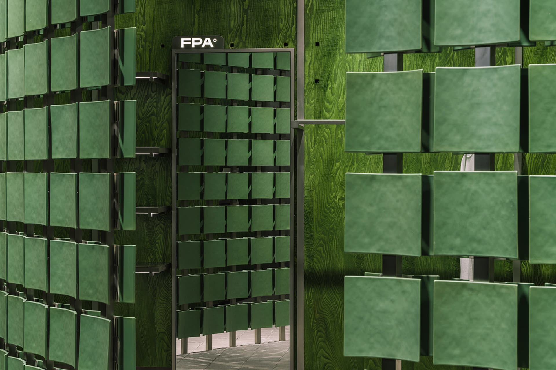 Modern storefront featuring glass panels on a green wooden exterior