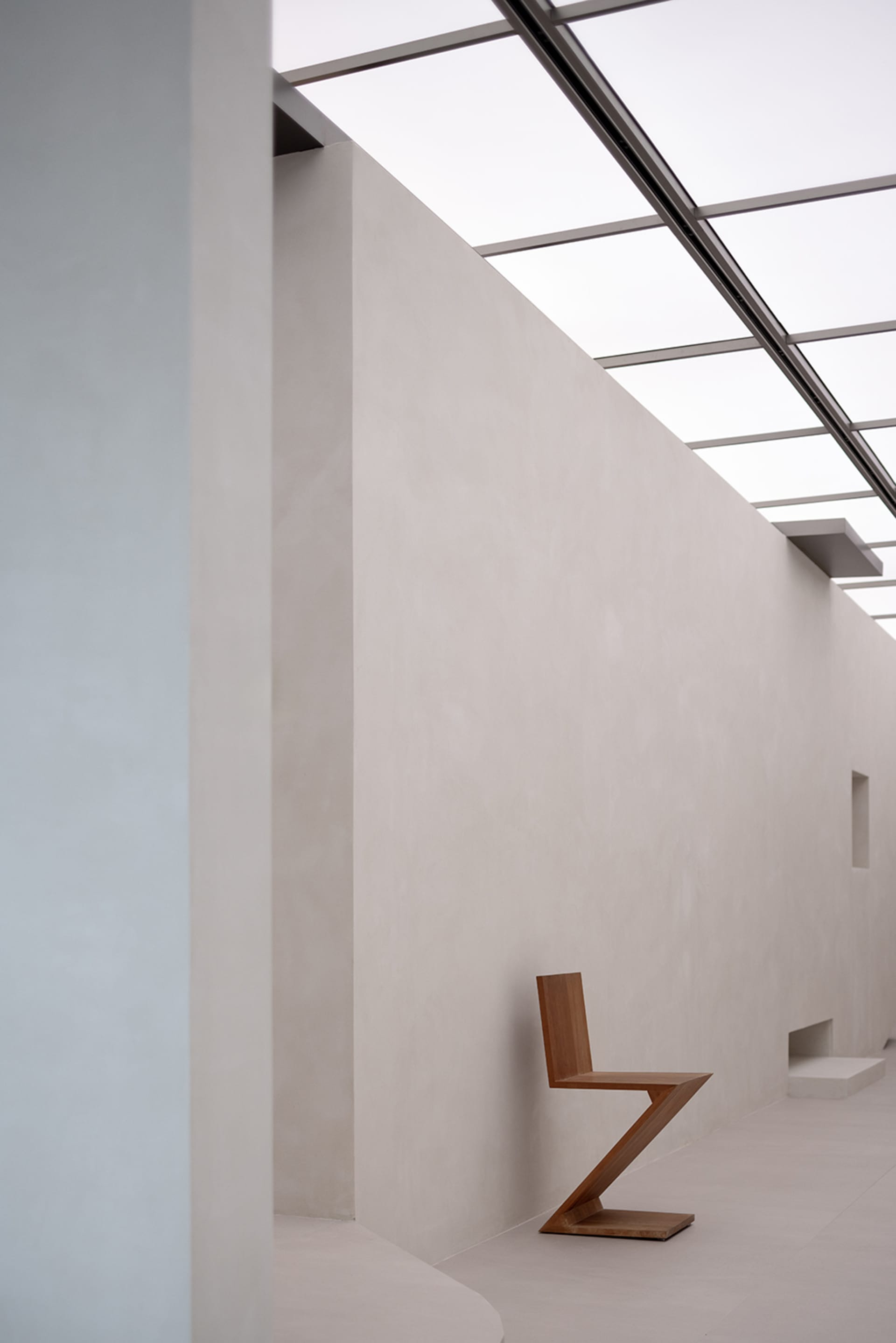 A modern, minimalist concrete lobby with geometric furniture and natural light.