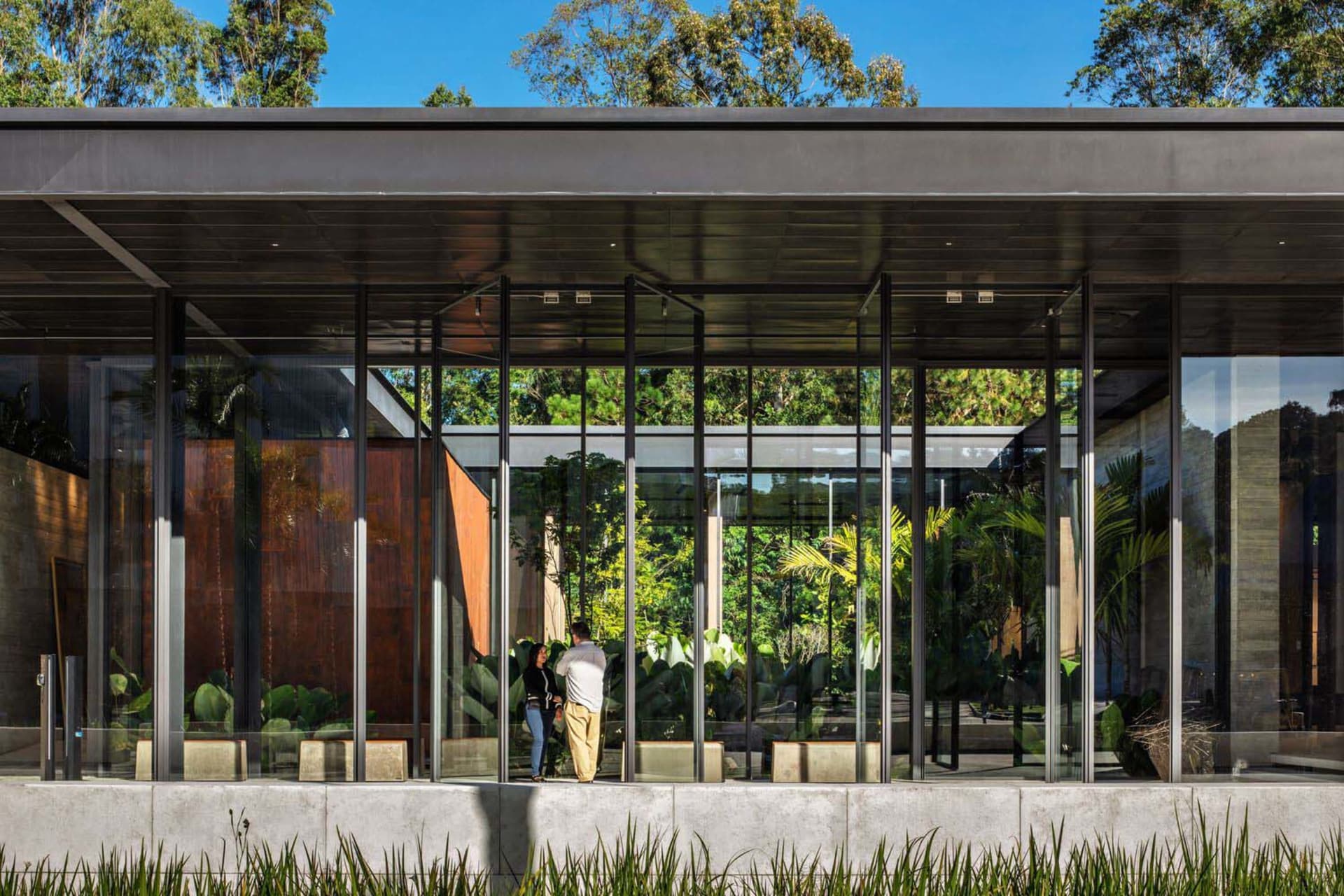 Modern residential entry featuring glass walls and concrete floor.