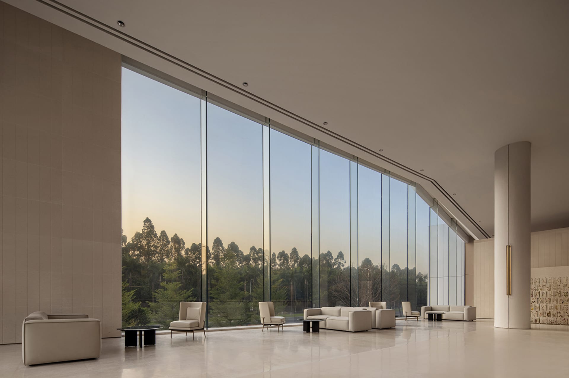 Modern lobby with large glass windows and minimalist furniture.