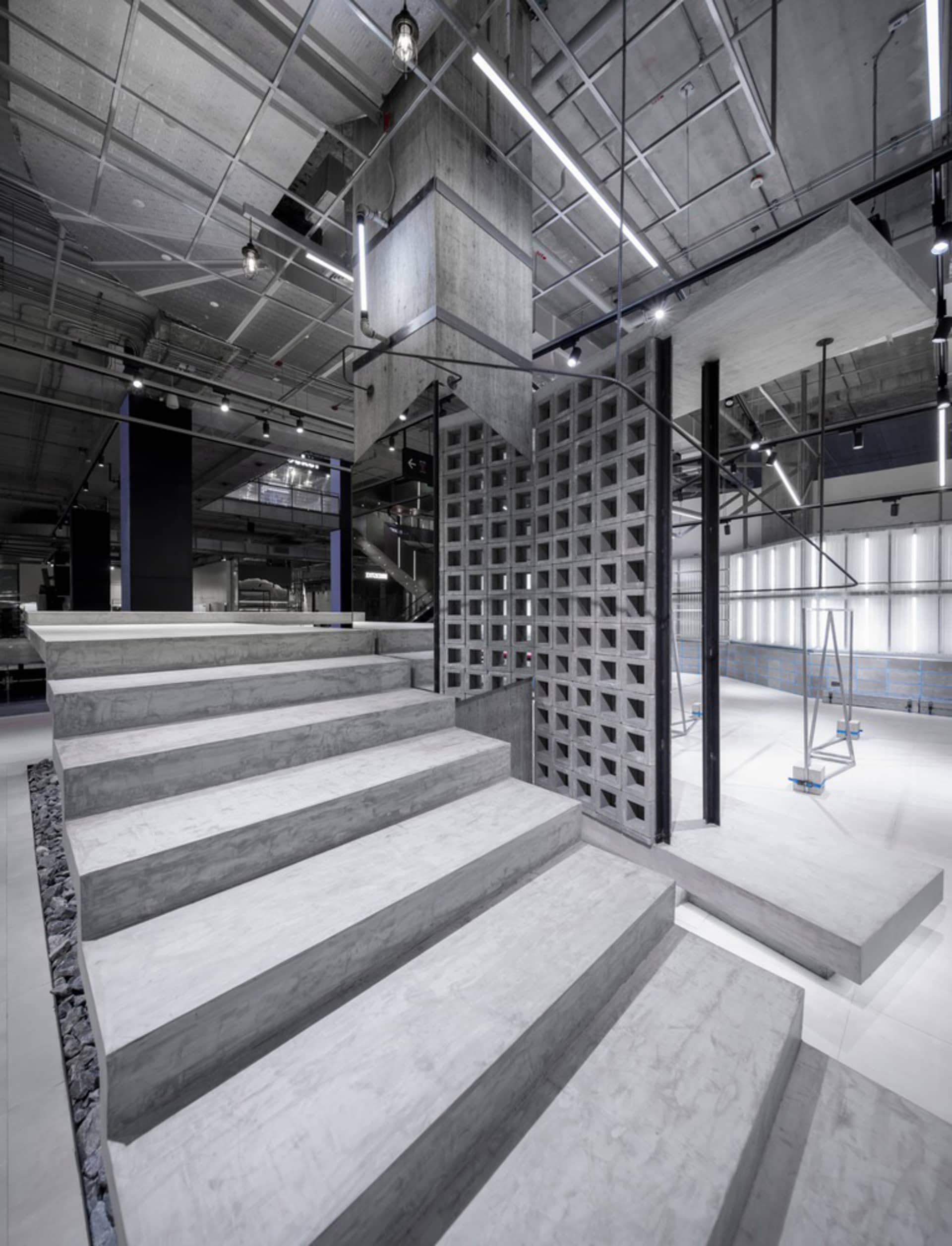 A modern commercial space with exposed concrete walls and a staircase.