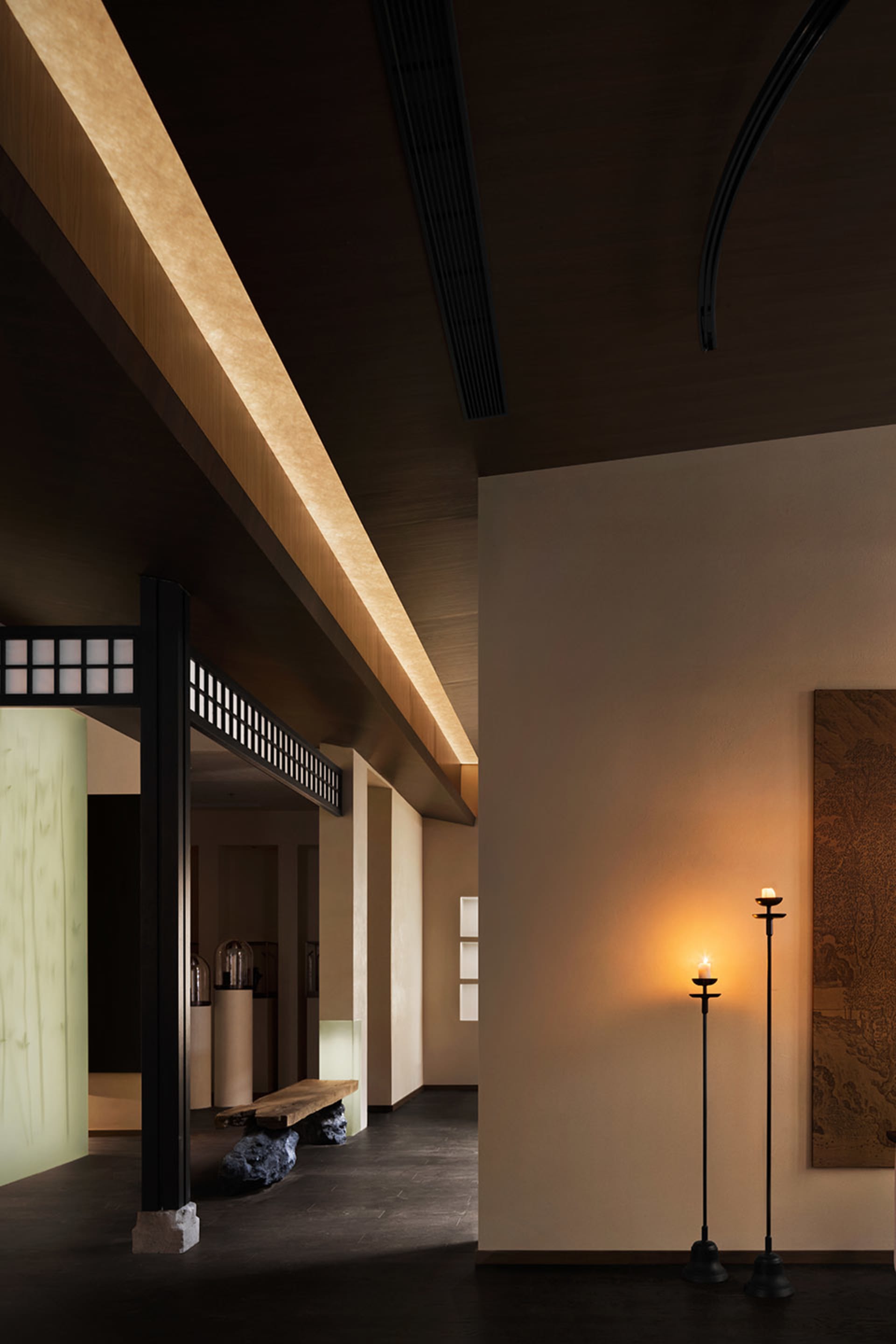 A modern lobby featuring plaster and glass materials, with warm lighting and minimalist design.