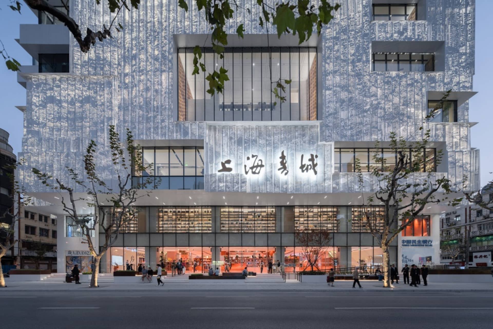 A modern retail storefront featuring metal cladding exterior and illuminated signage.