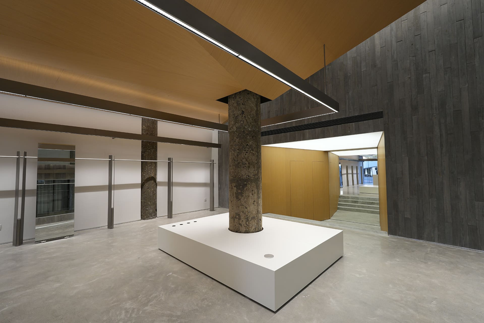A minimalist commercial space featuring concrete and wood materials.