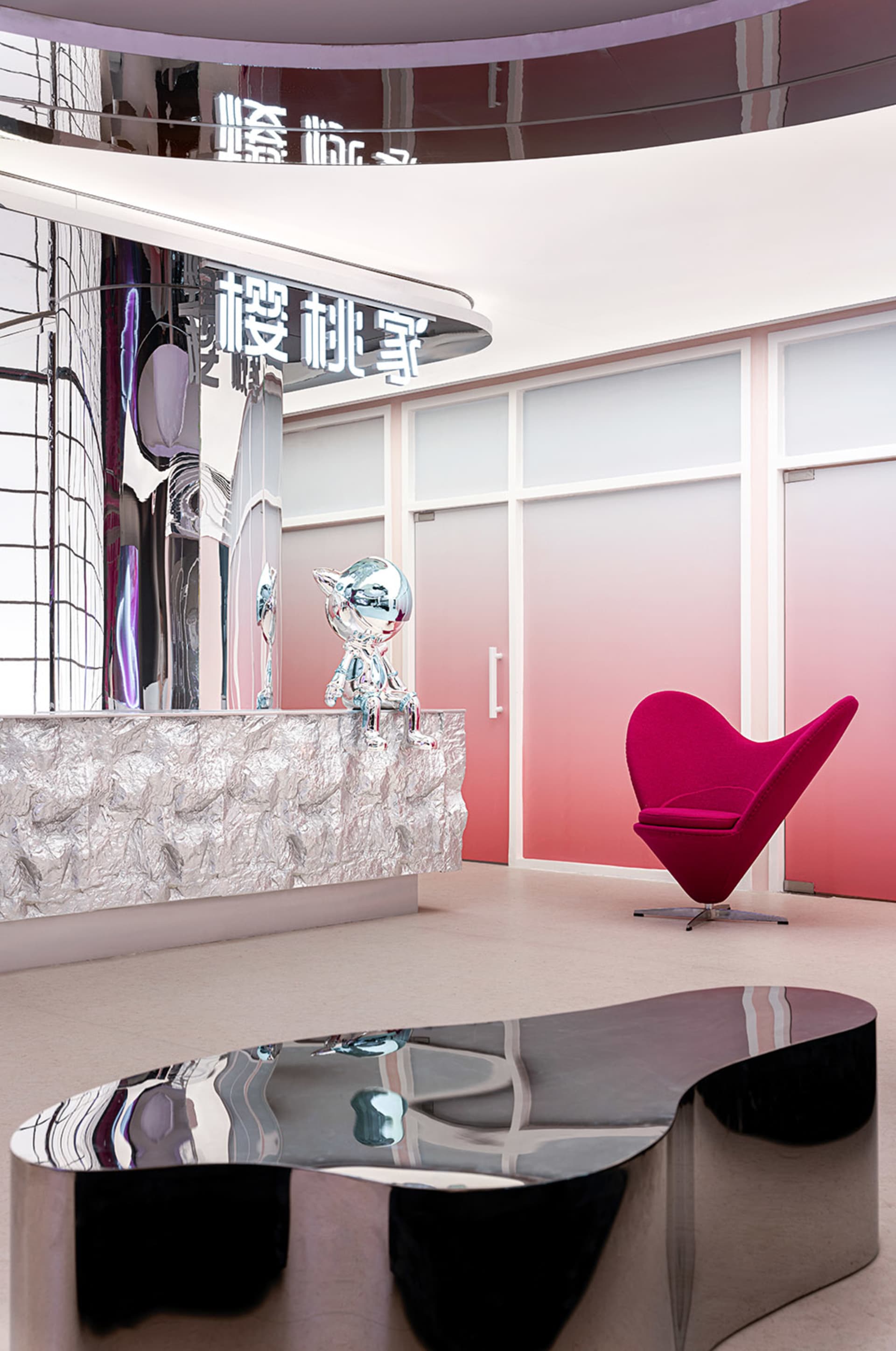 Modern minimalist lobby with metallic furniture and silver counter.