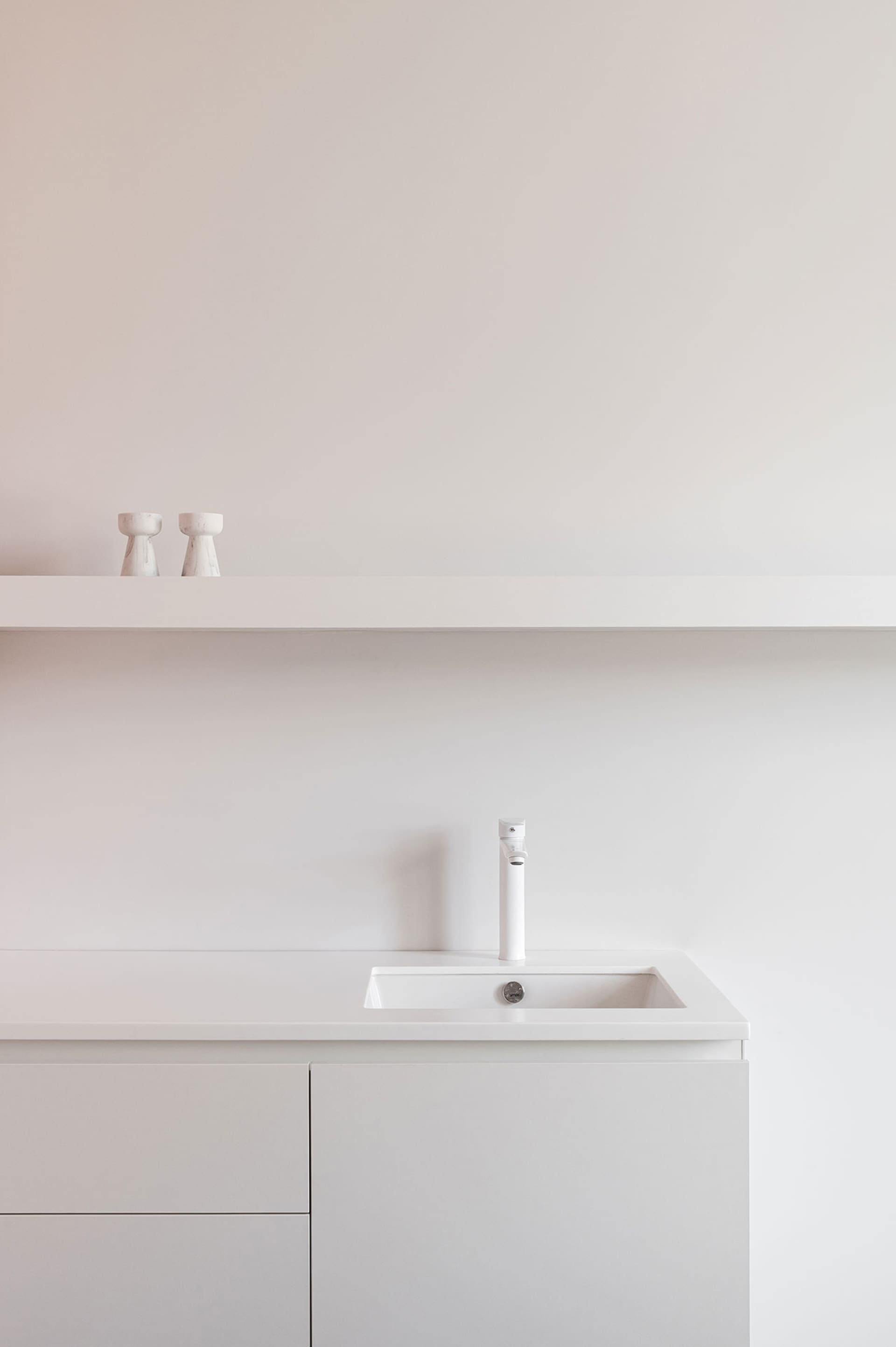 Modern minimalist bathroom with white fixtures and a sleek design.