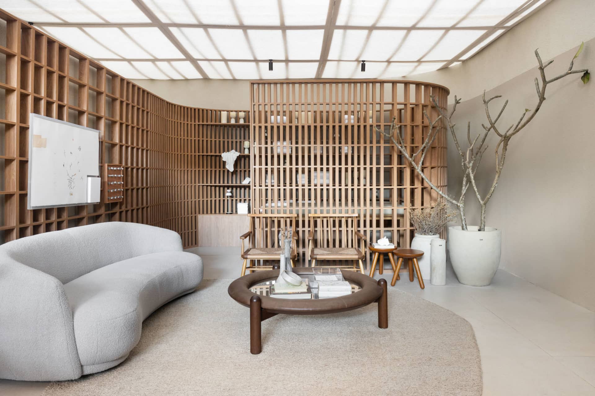 Modern living room featuring a curved sofa, round table, and wooden panels on the walls and ceiling.