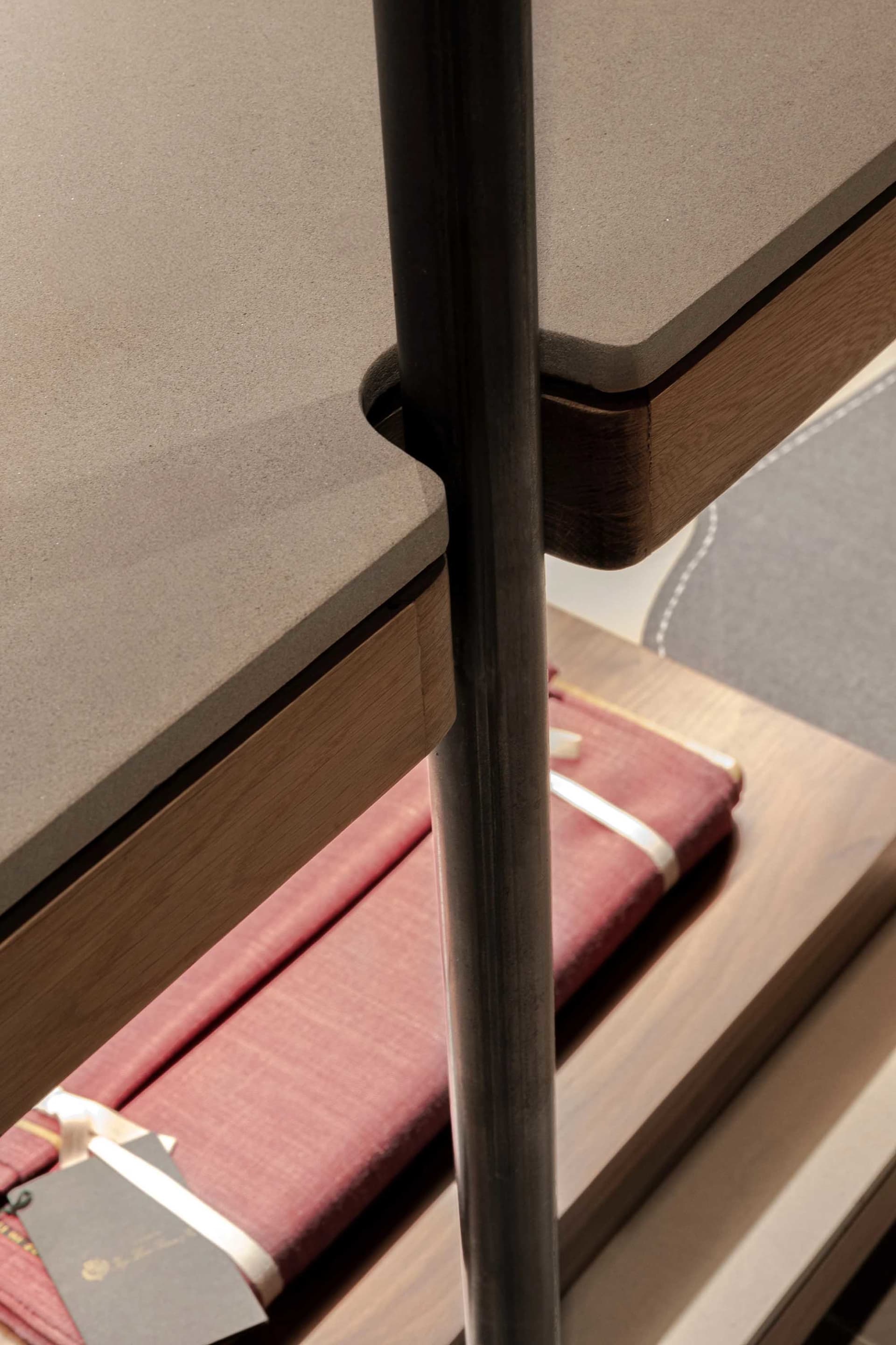Modern metal and wood bookshelf display with books inside.