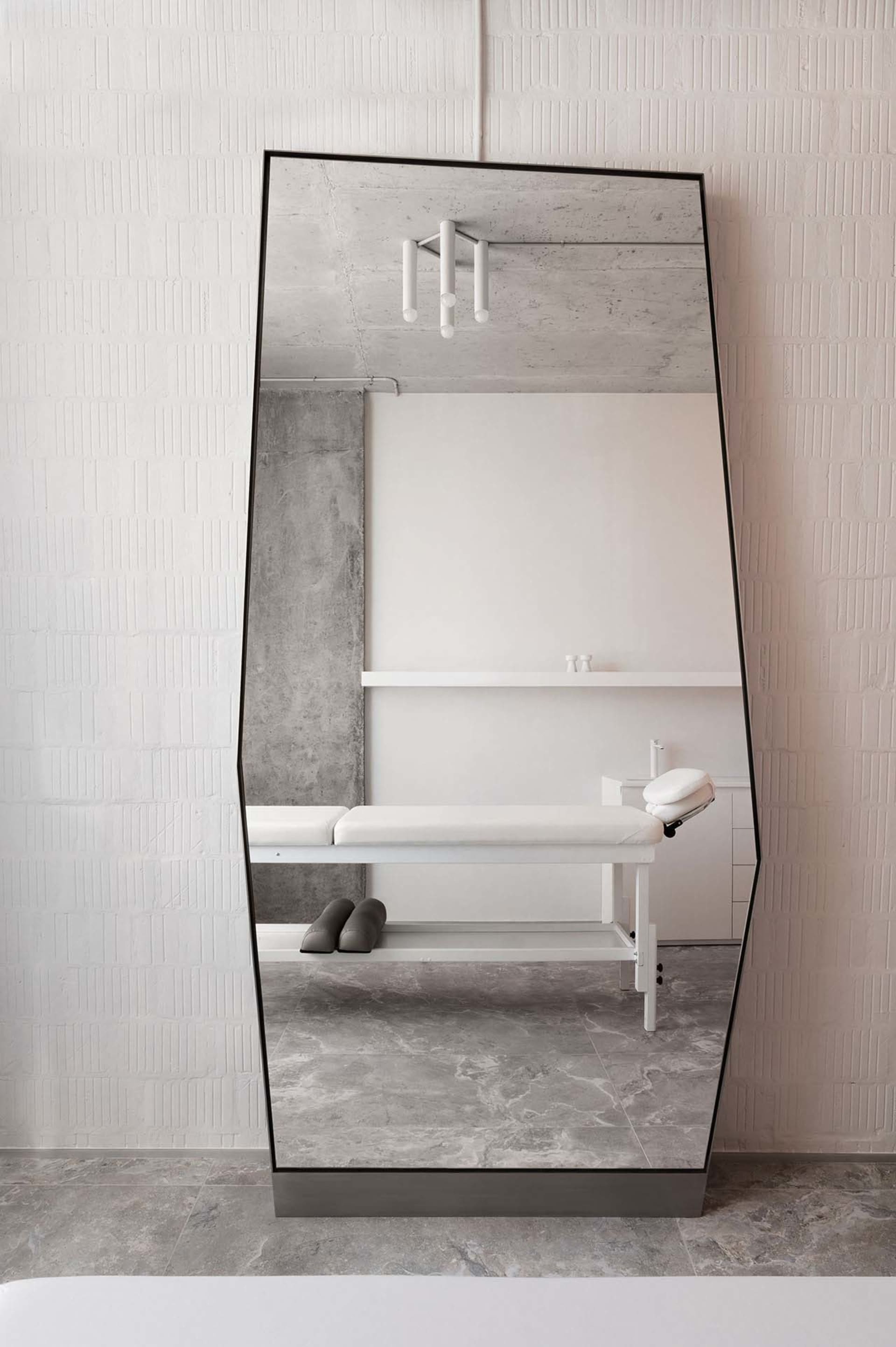A modern spa interior with a textured concrete wall and minimalist design.