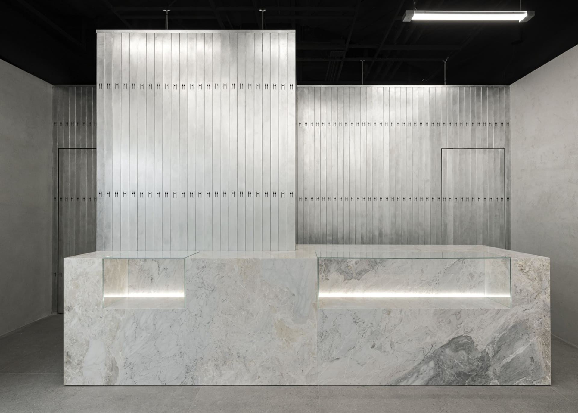Modern industrial-style reception desk made of metal and marble materials.