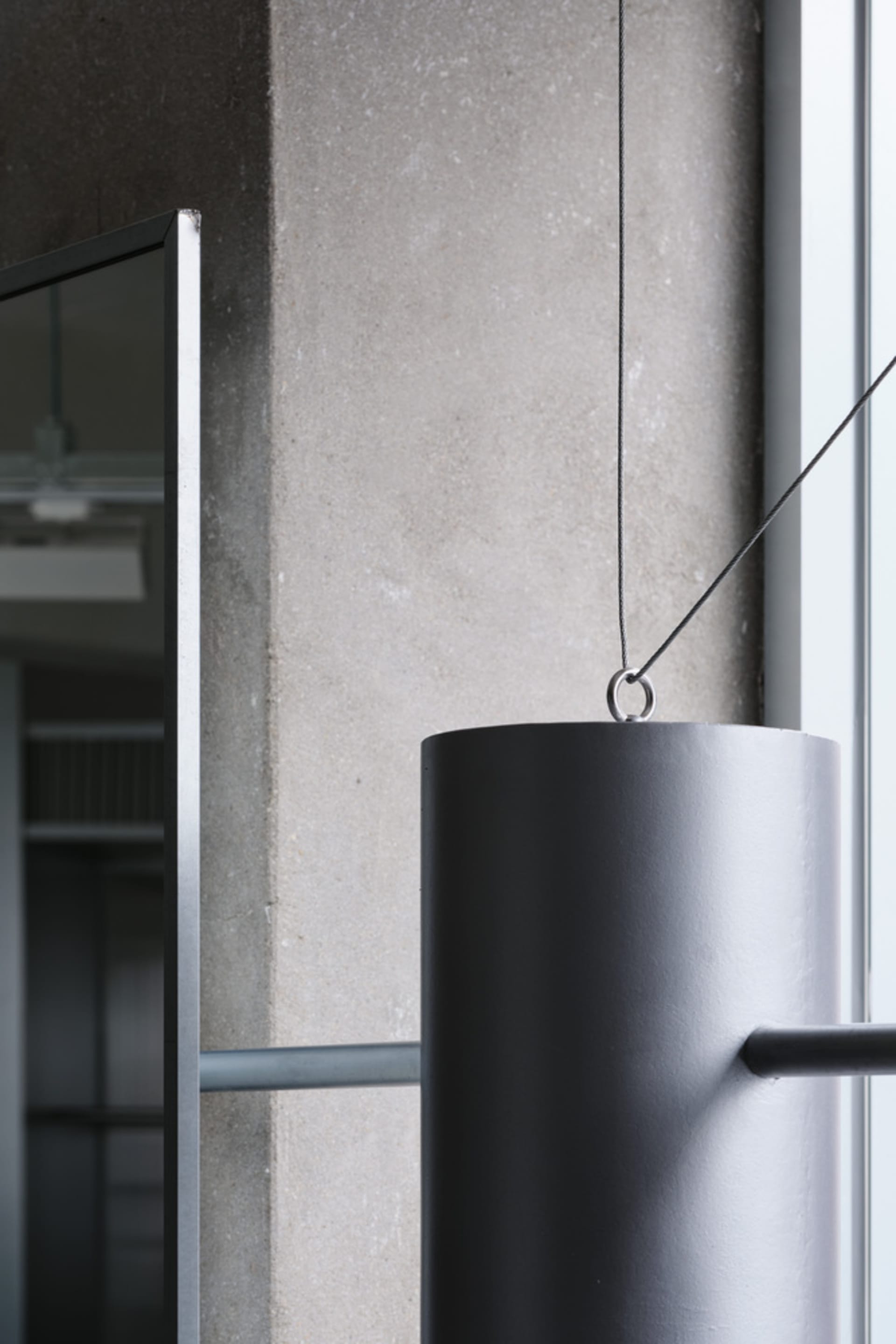 A modern office space featuring grey concrete columns and metal elements.