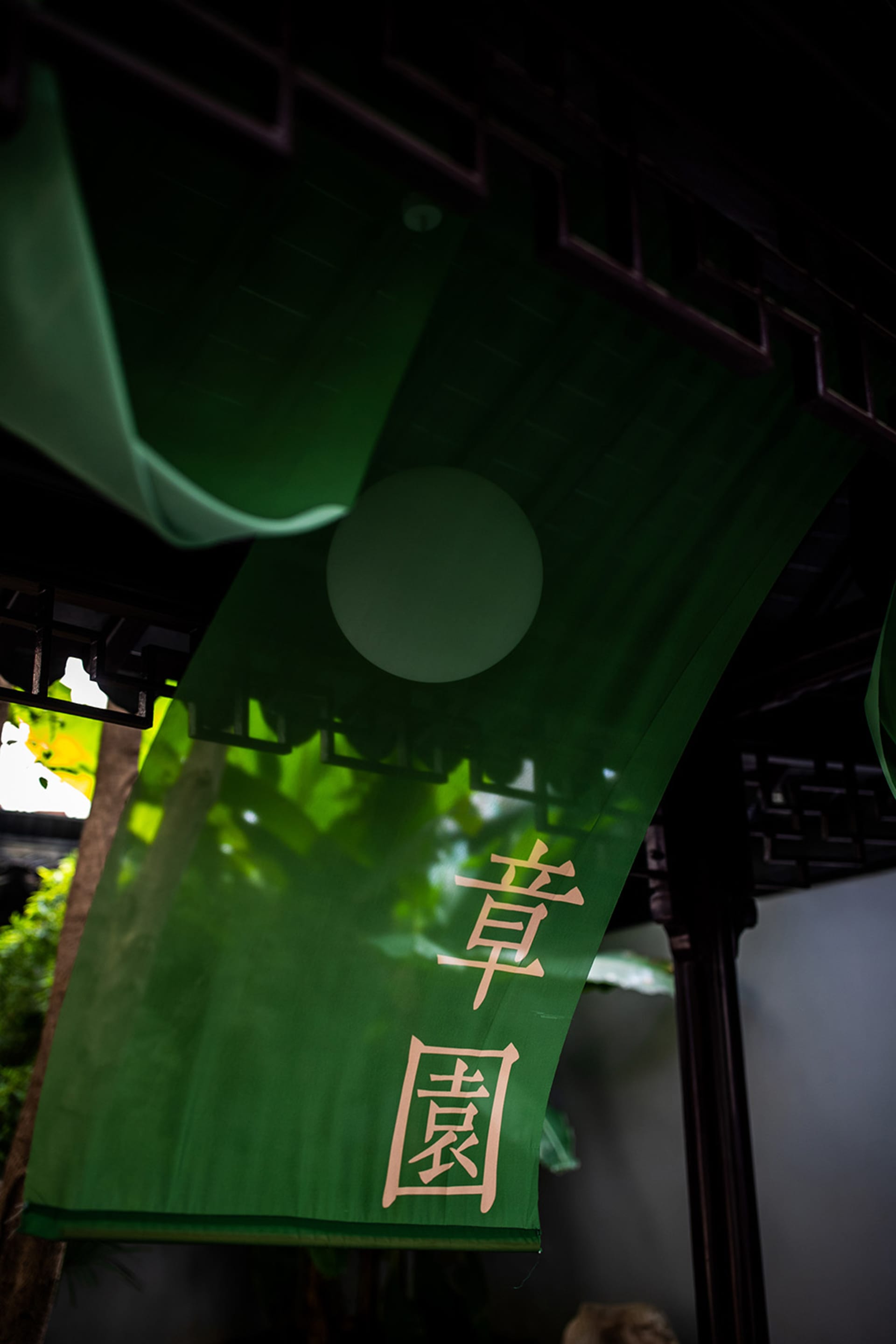 綠色布幔上寫有中文字，懸掛在木樑上