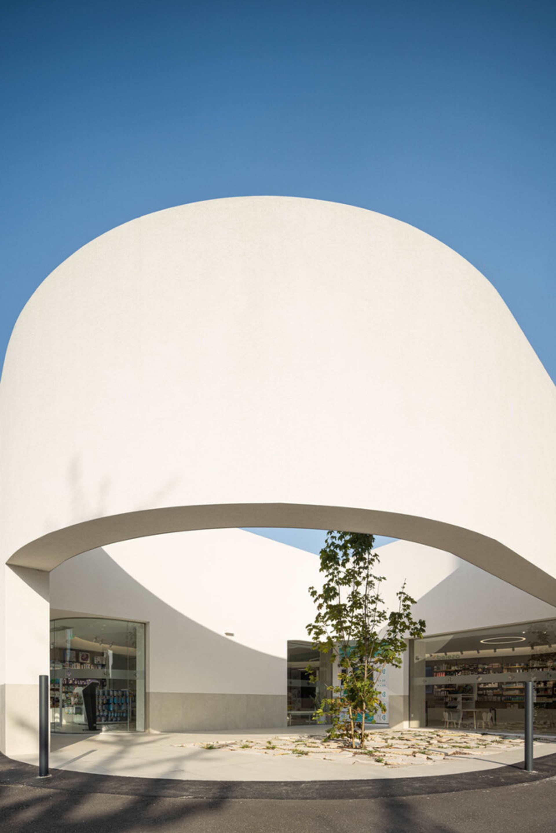 Modern white concrete public library entry with a curved archway.