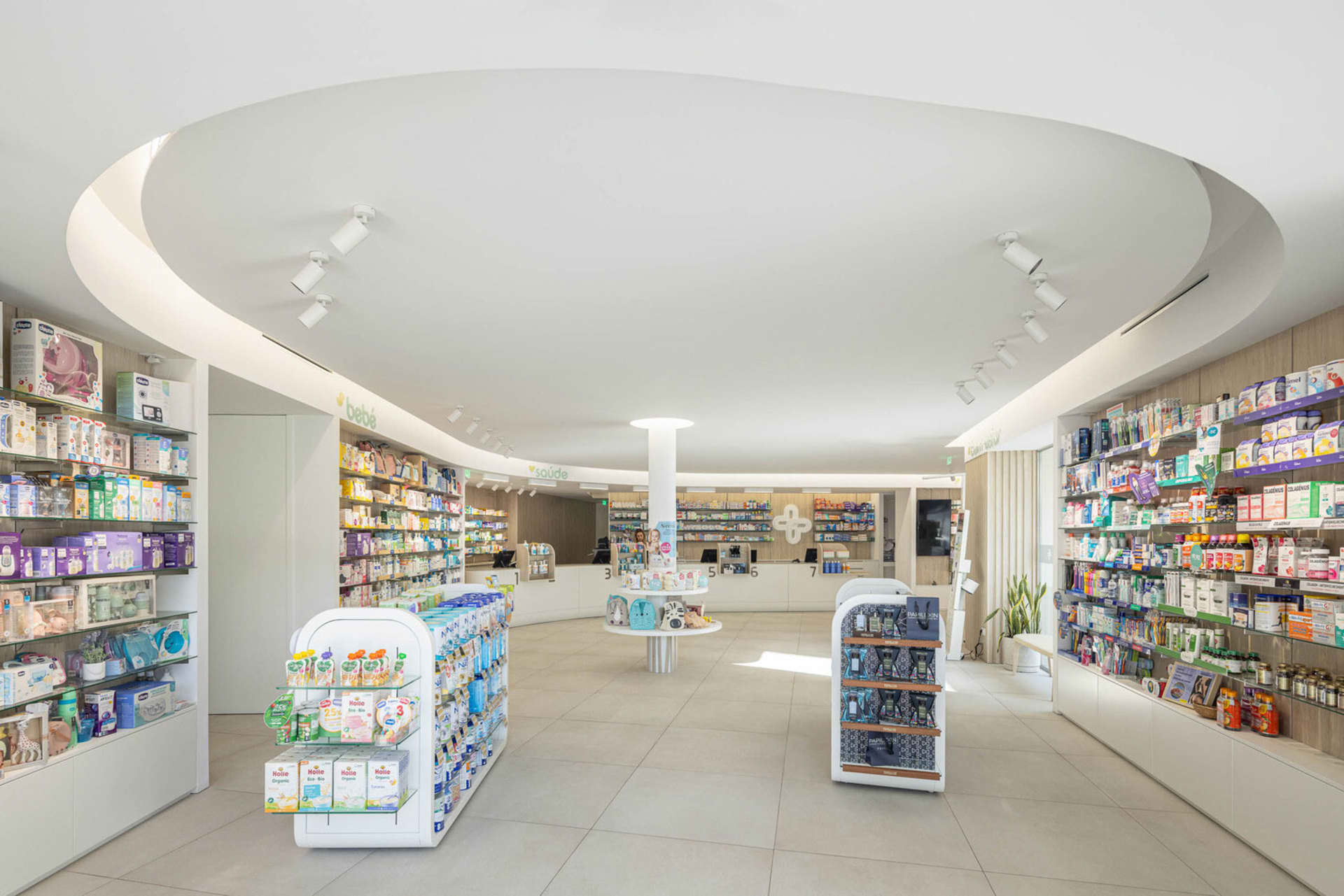 A modern retail space with white concrete flooring, glass display cases, and metal shelves.