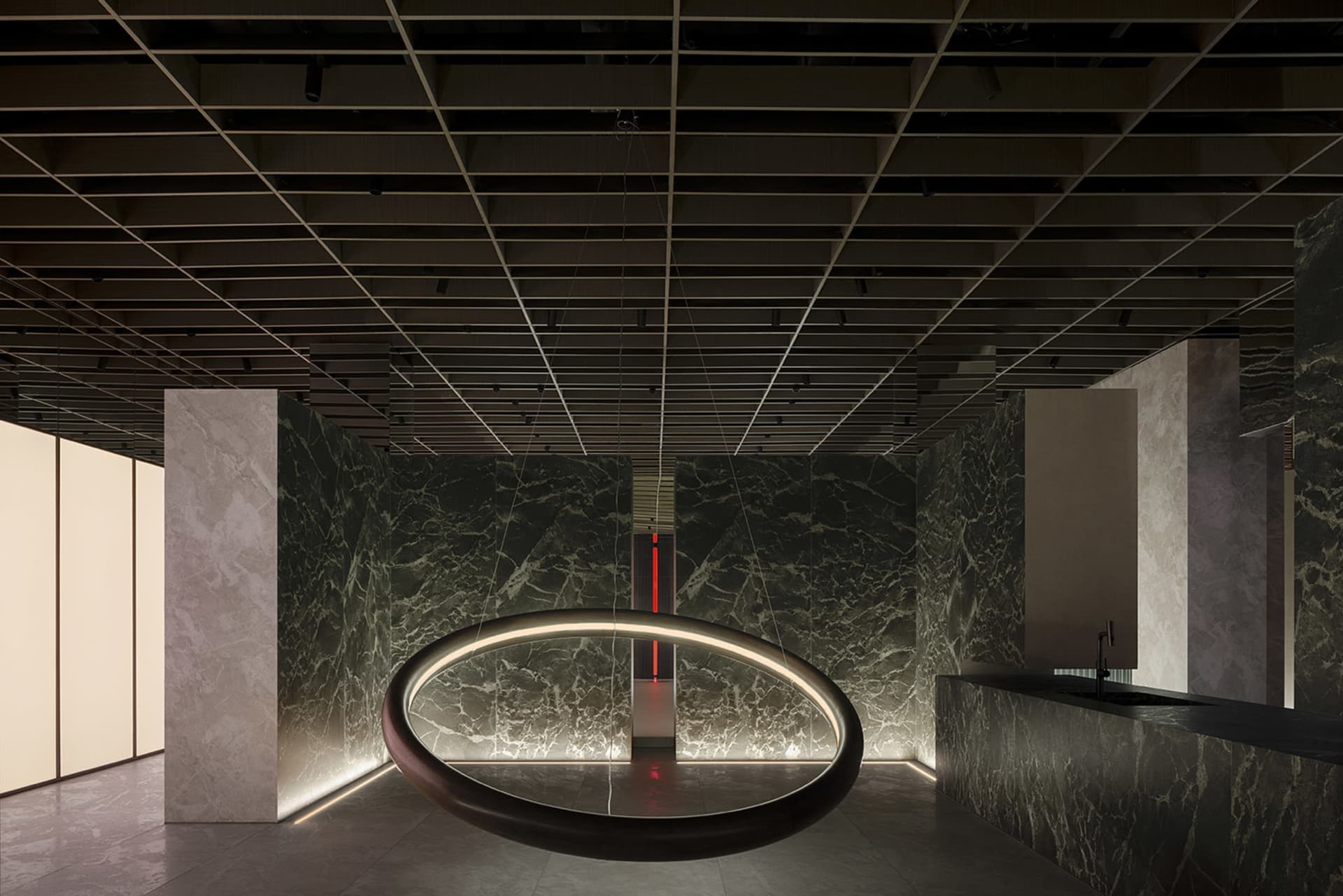 A modern public space featuring marble walls and lighting.
