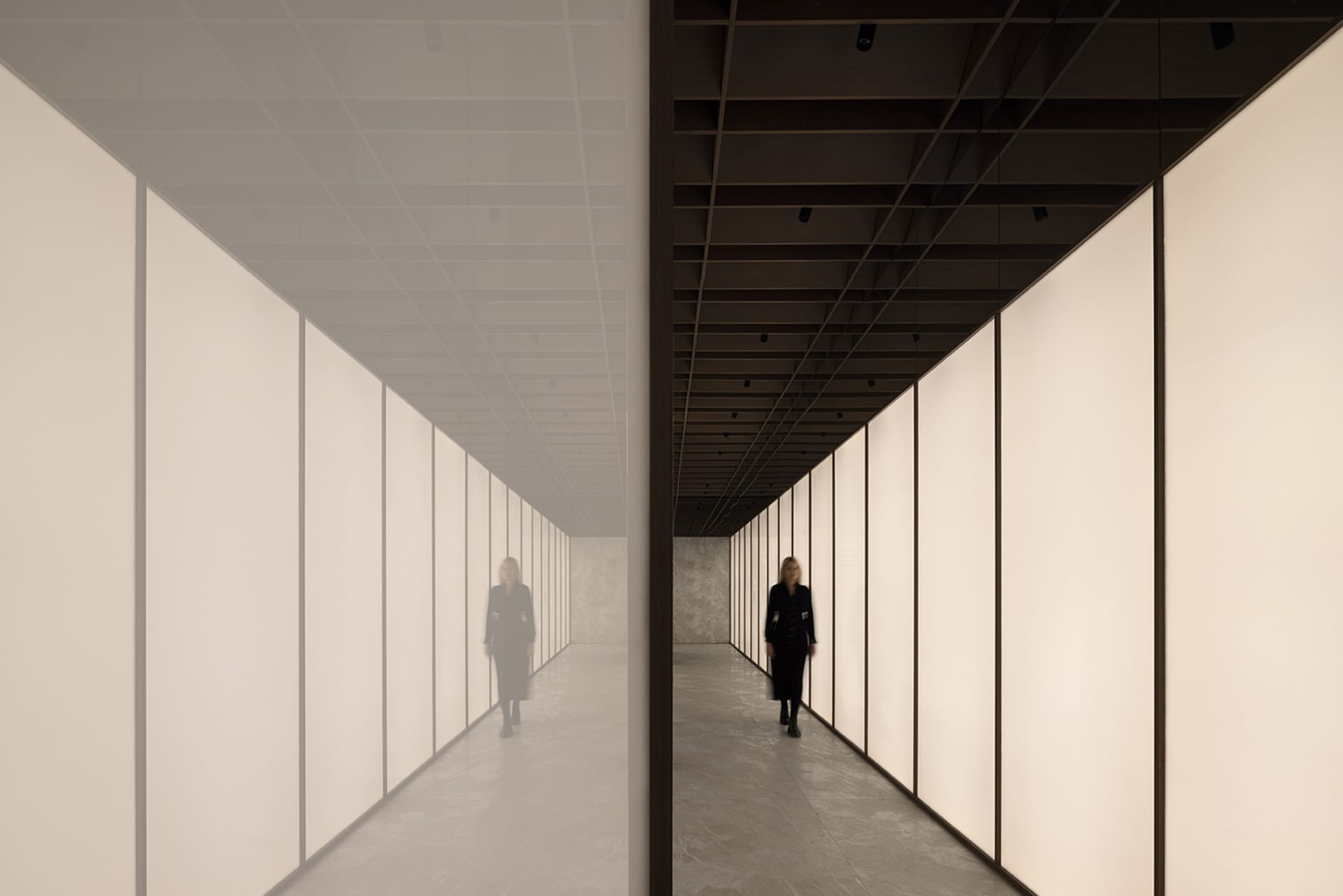 A minimalist corridor featuring glass walls and reflections.