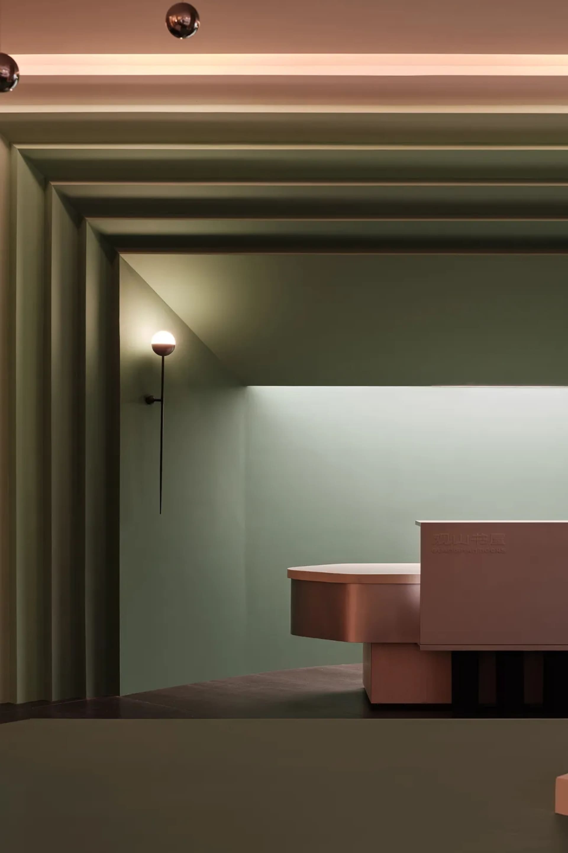 A minimalist modern library with a sleek metal countertop and green walls.