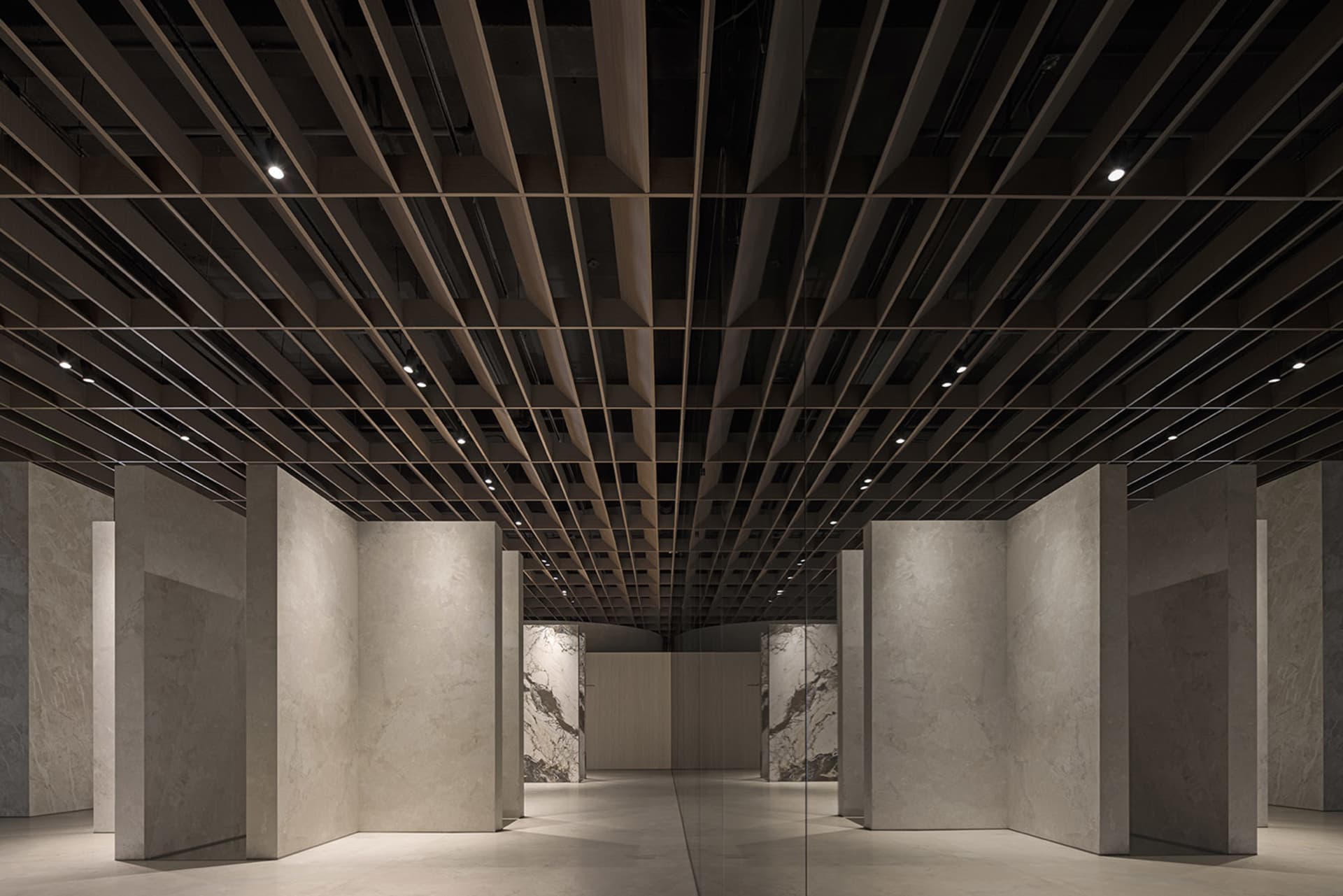 Interior of a modern office with marble walls and concrete columns.