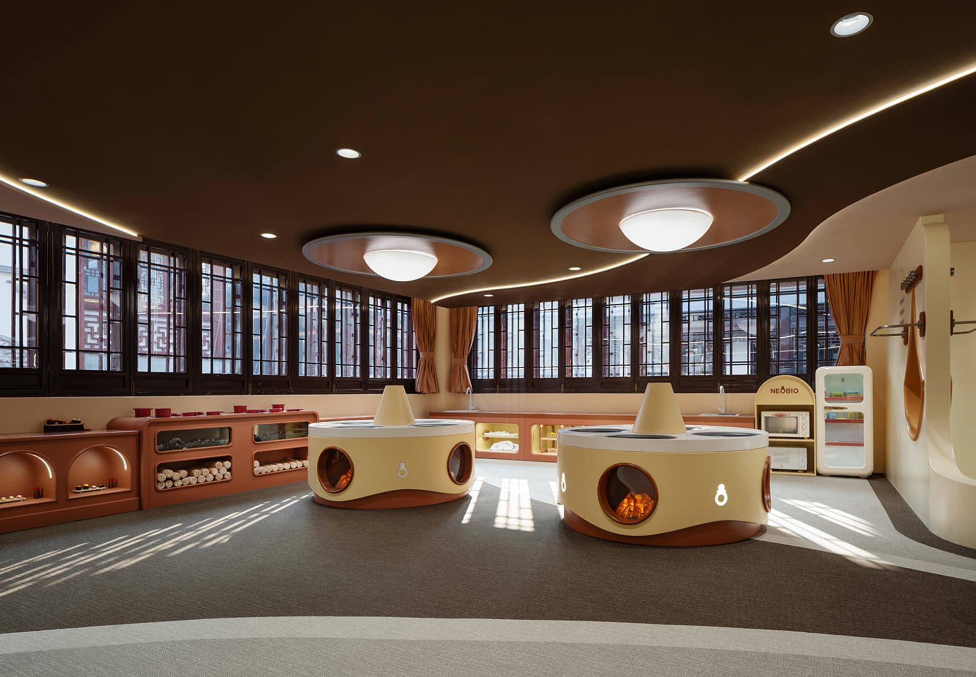 A modern playroom featuring wooden furniture, glass panels, and metallic elements.