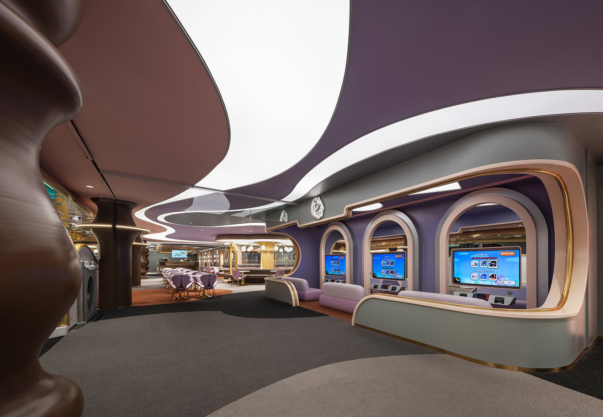 Interior view of a modern restaurant featuring metallic finishes, curved glass panels, and geometric shapes.