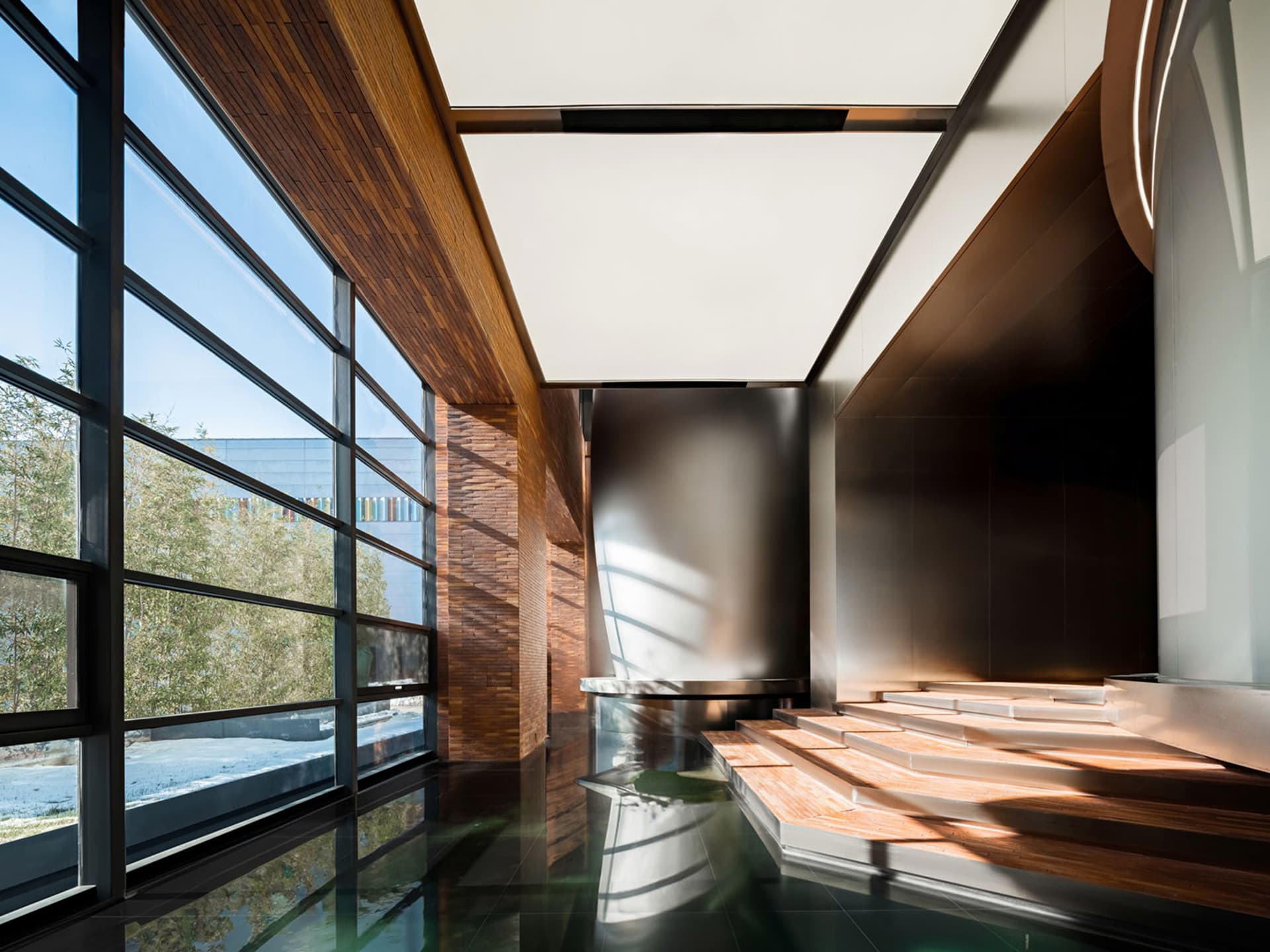 Modern lobby design featuring large glass windows and wooden elements.