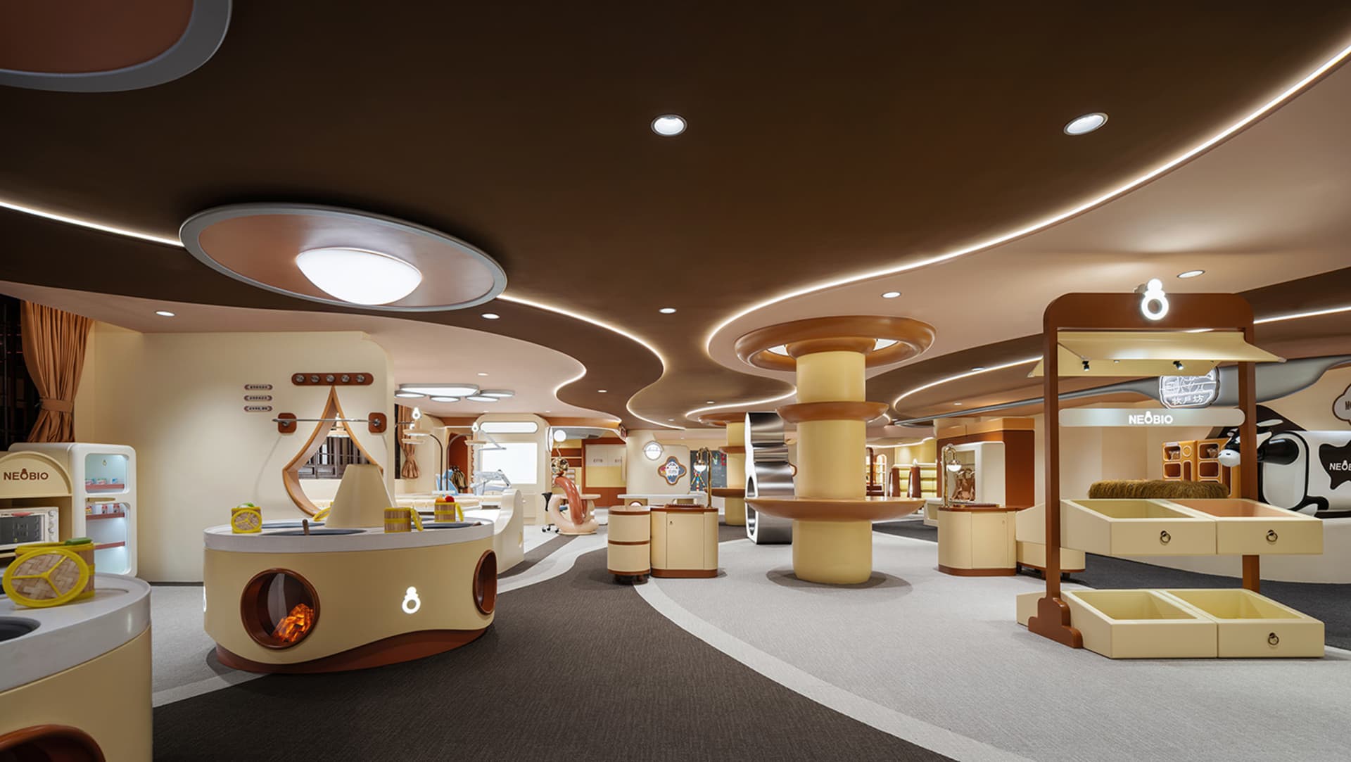 Modern retail store with a neutral color scheme featuring a round counter, display shelves, and various retail items.