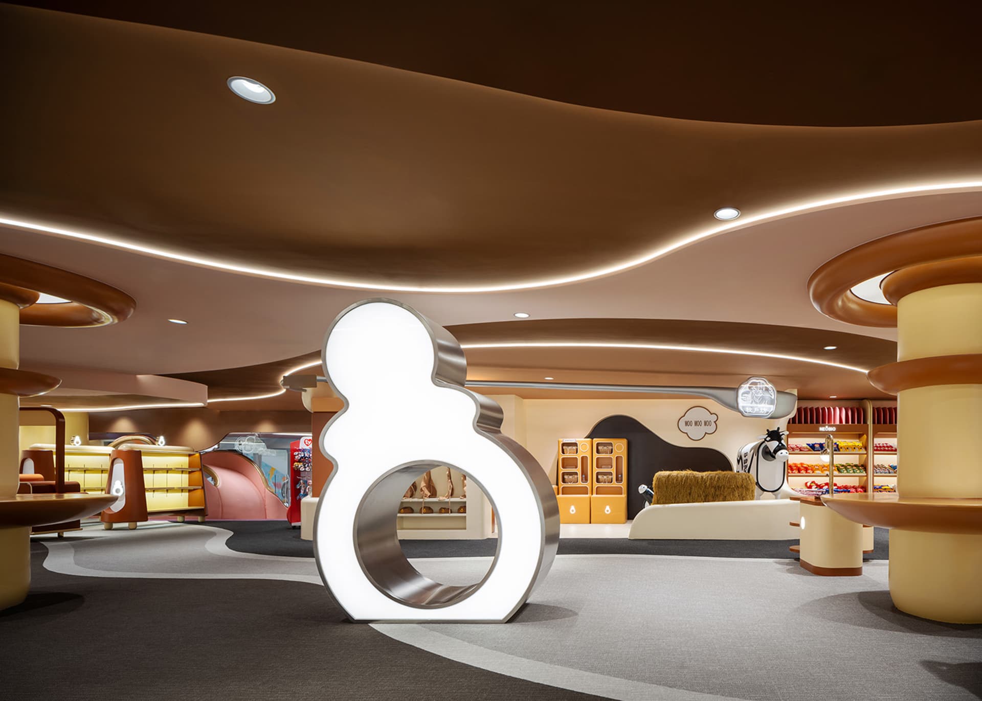 An indoor retail space featuring metallic lighting fixtures and a large illuminated sculpture.