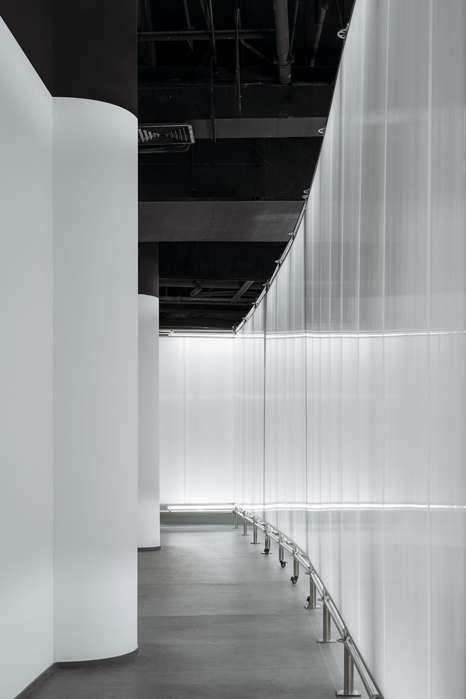 現代工業風室內空間，展現金屬元素與半透明玻璃隔板。
