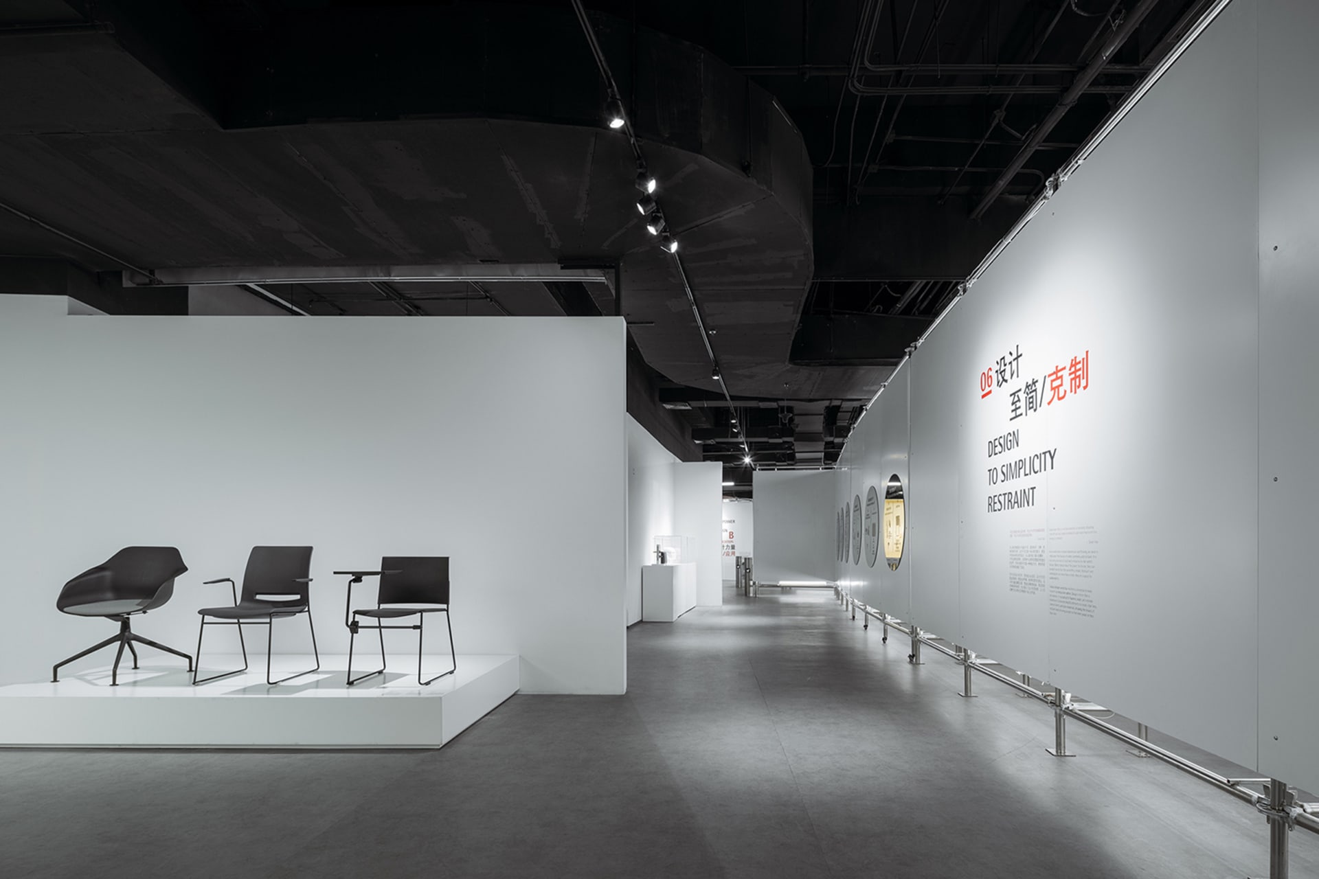 Modern exhibition space with minimalist design, featuring concrete and white materials.