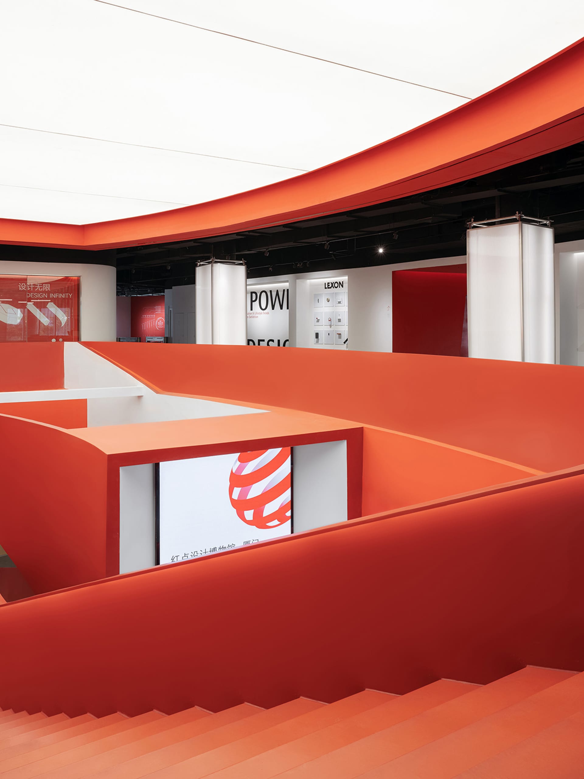 A contemporary exhibition space with vibrant orange walls and curved architectural elements.