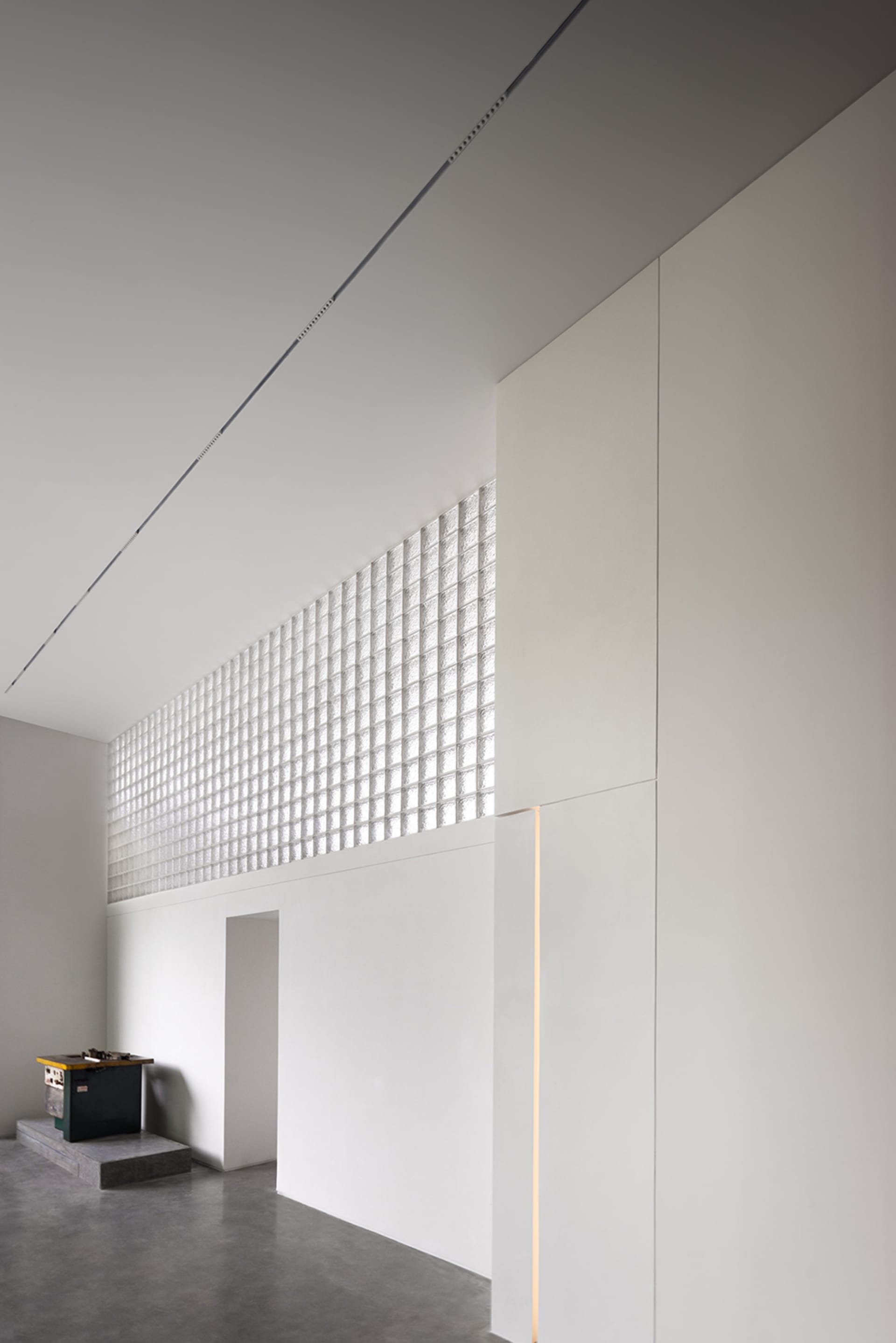 A minimalist architectural space featuring glass windows and walls.