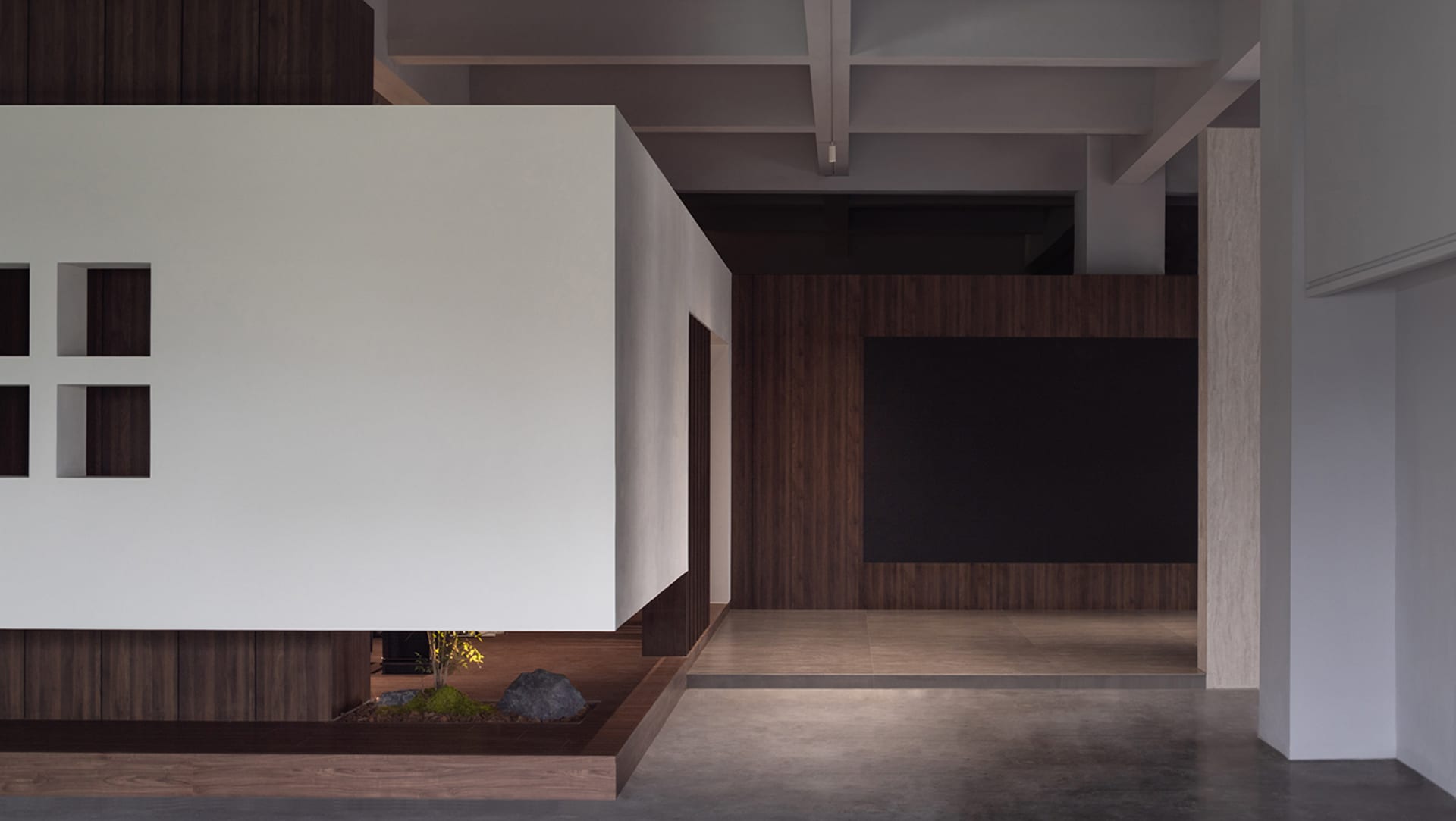 A modern living room featuring concrete flooring, wooden paneling, and minimalist decor.