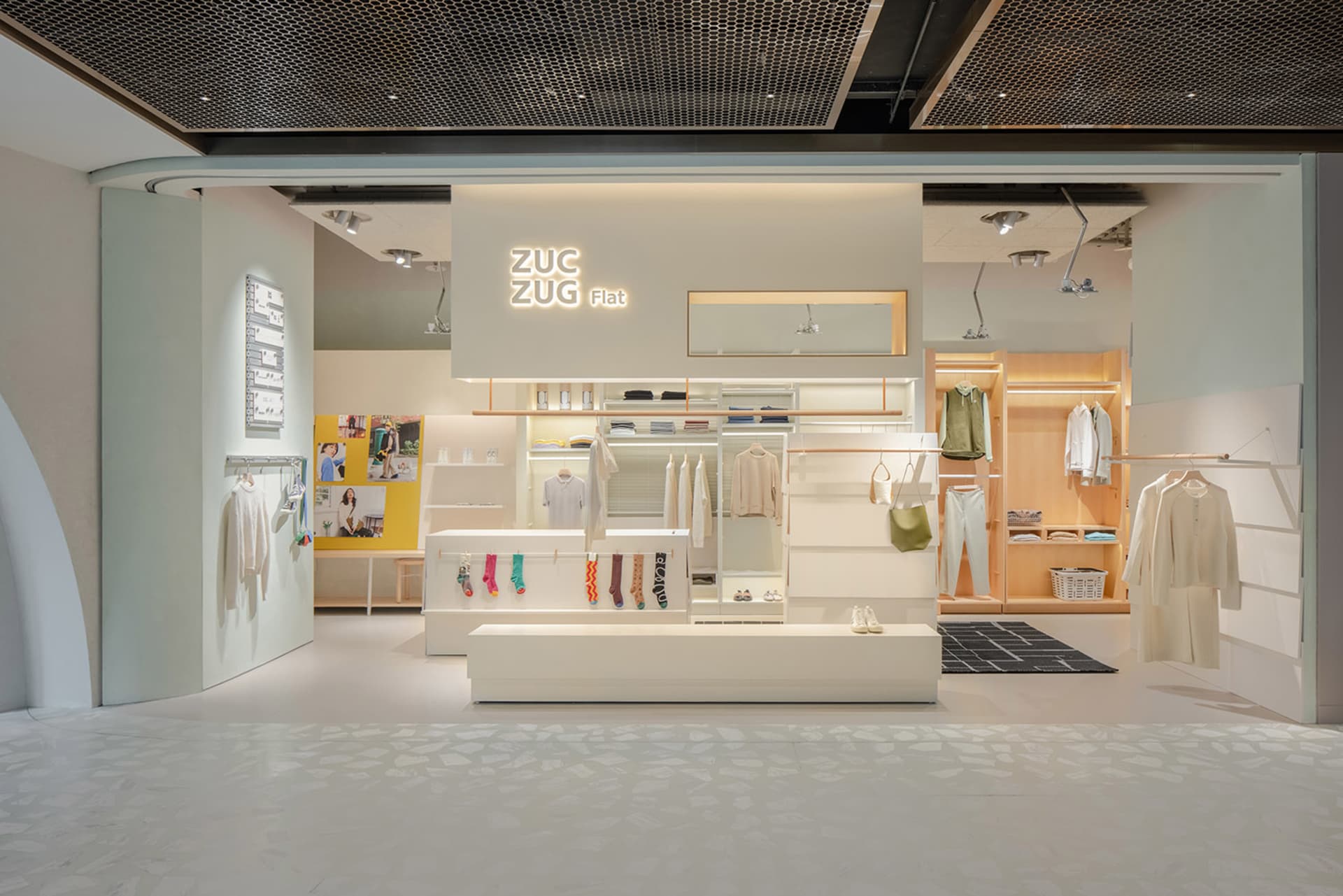Modern white concrete clothing shop with minimalist design.