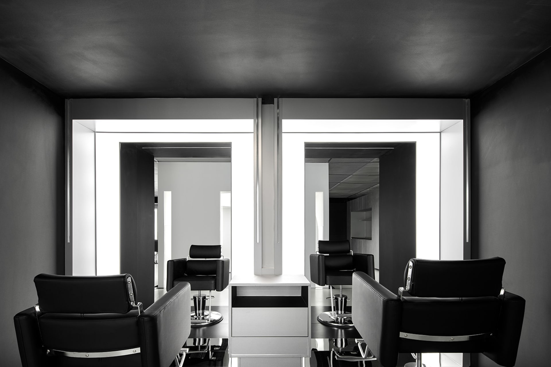A modern salon interior featuring black cabinets and sleek, minimalist design.
