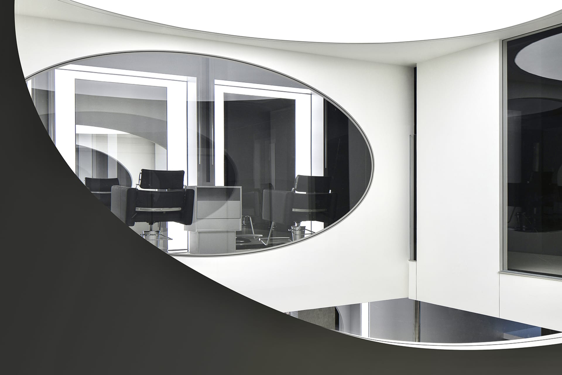 A modern office space featuring glass walls and contemporary office furniture.