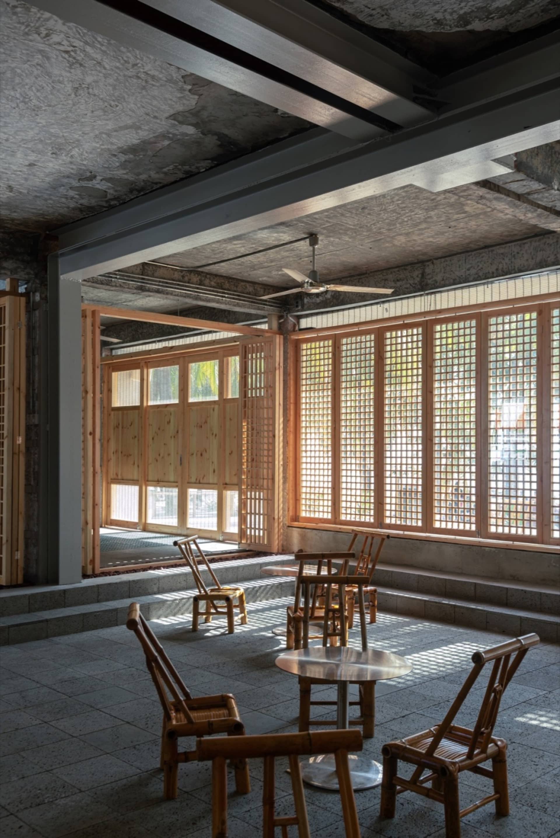 An industrial-style coffee shop interior with wooden furniture and concrete walls.