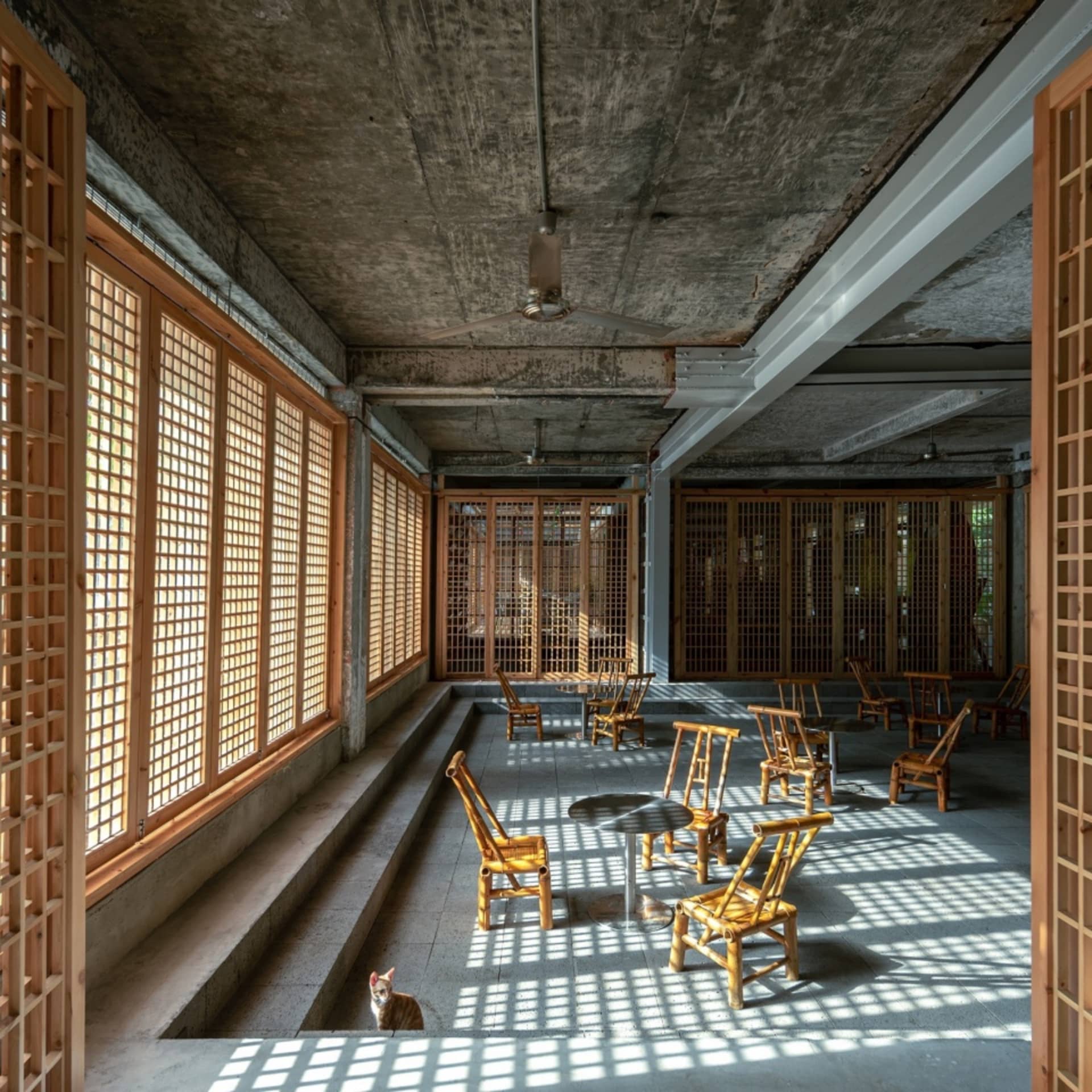 工業風餐廳內部,混凝土天花板、木質牆面,以及大面玻璃窗。