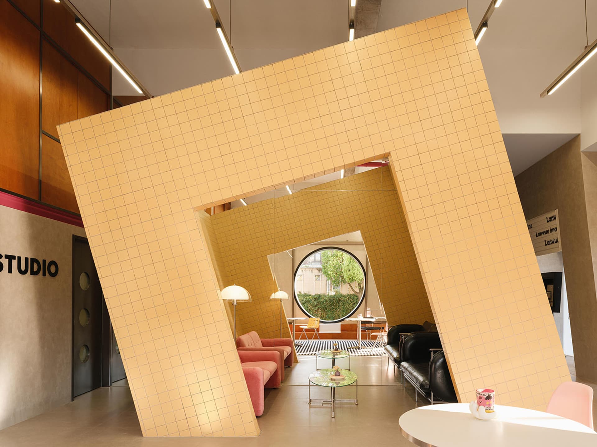 A modern interior space with a large tiled wall and colorful furniture.