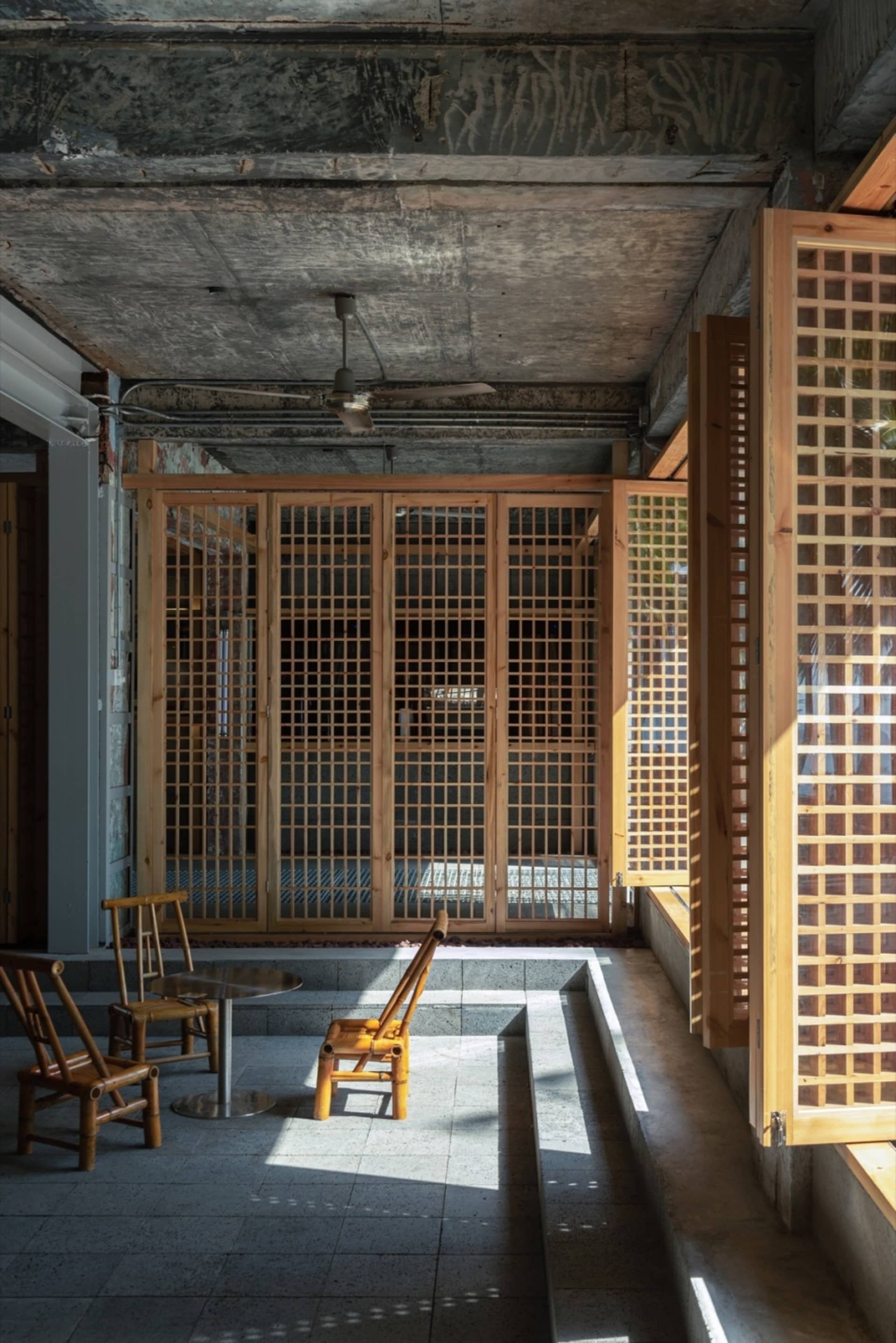 Industrial-style room with wooden grid walls and ceiling fan