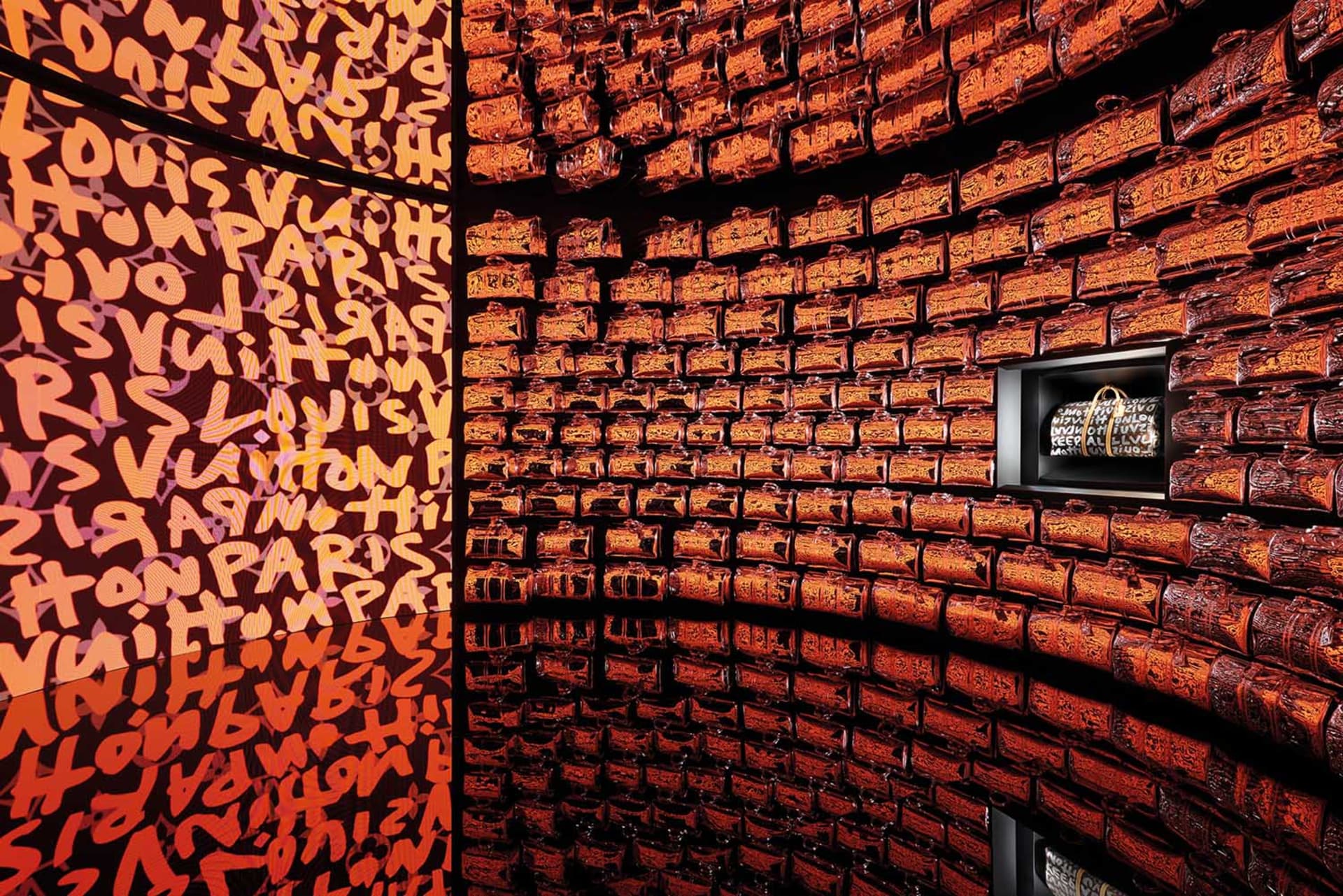 An indoor display showcasing numerous Louis Vuitton bags made of wood.
