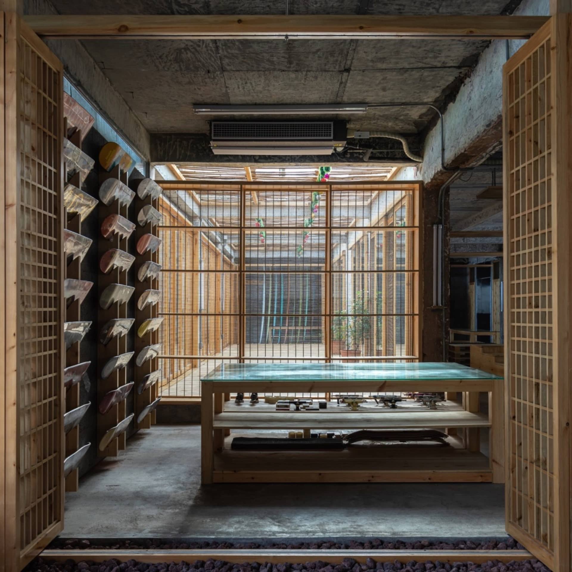 極簡餐廳室內，混凝土地板、木質牆面，以及大型玻璃窗。