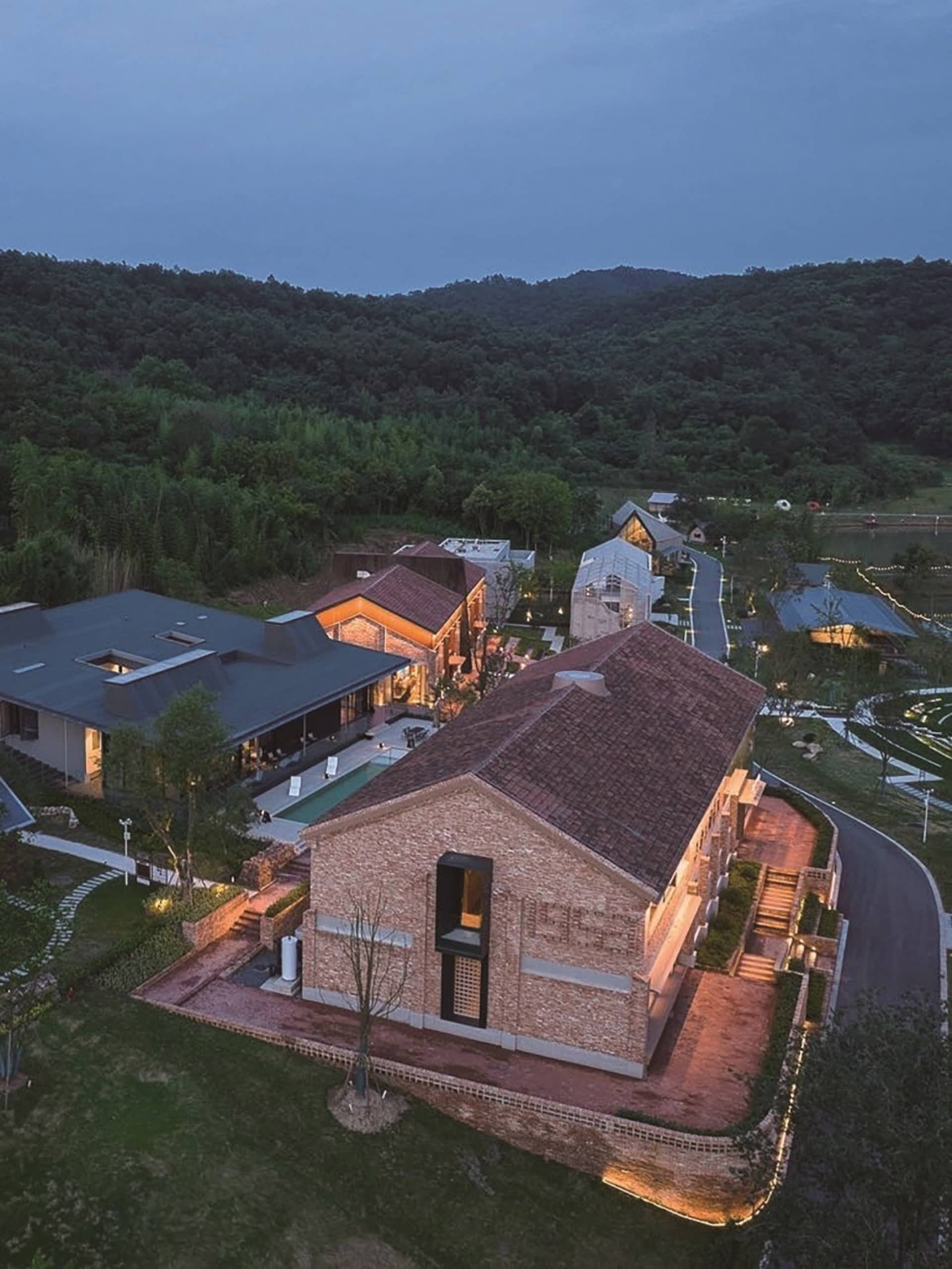 一座以磚塊建造的現代建築，周圍環繞著綠意與樹木。