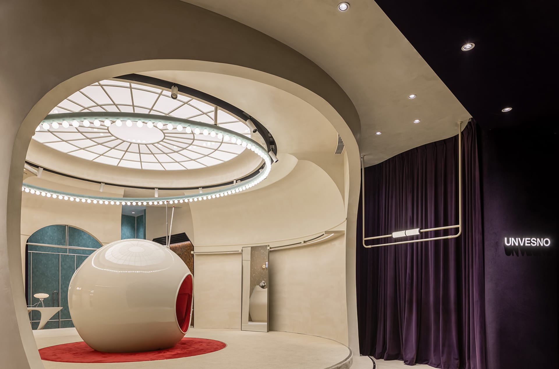 A modern, futuristic interior design with a spherical seating area, geometric lighting, and a large, dark curtain.