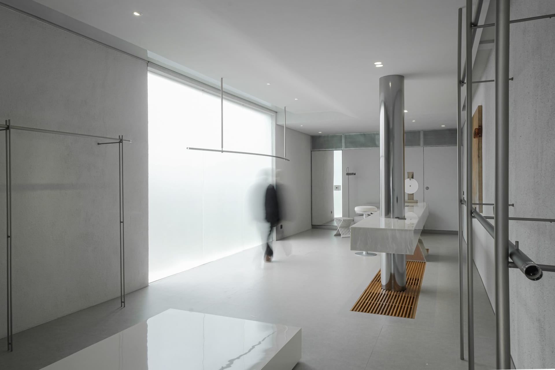 A modern minimalist office space featuring glass and metal elements.