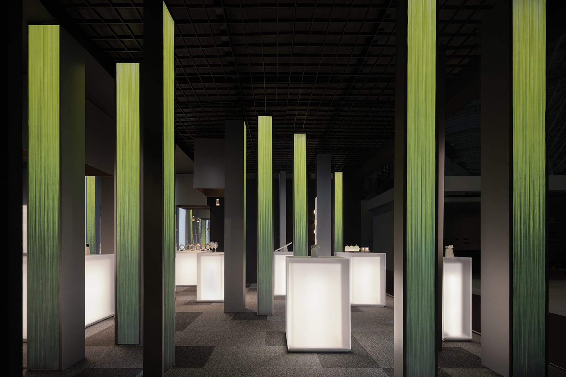 An interior exhibition space featuring modern LED columns and carpeting.