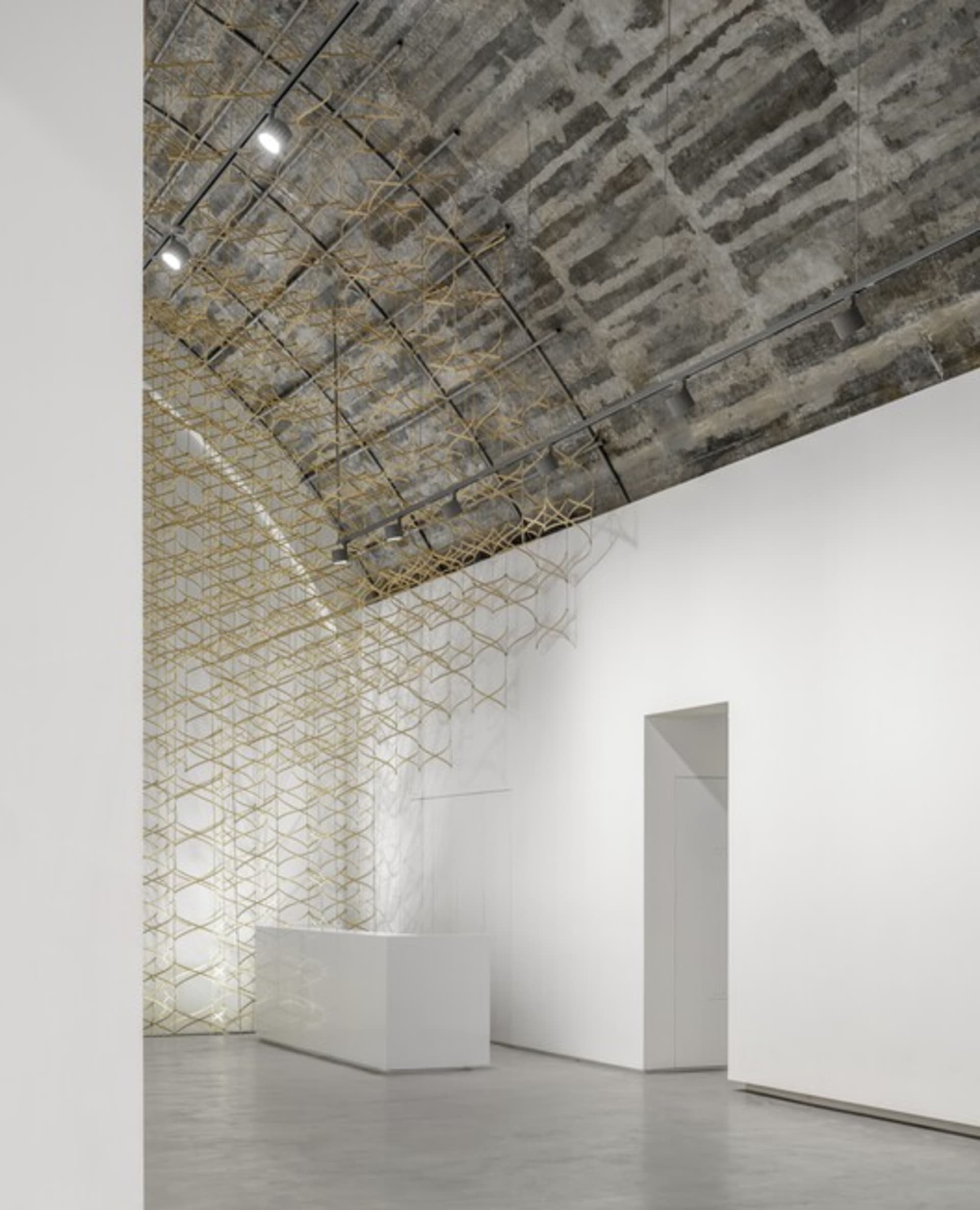 Minimalist art installation featuring metal mesh and concrete