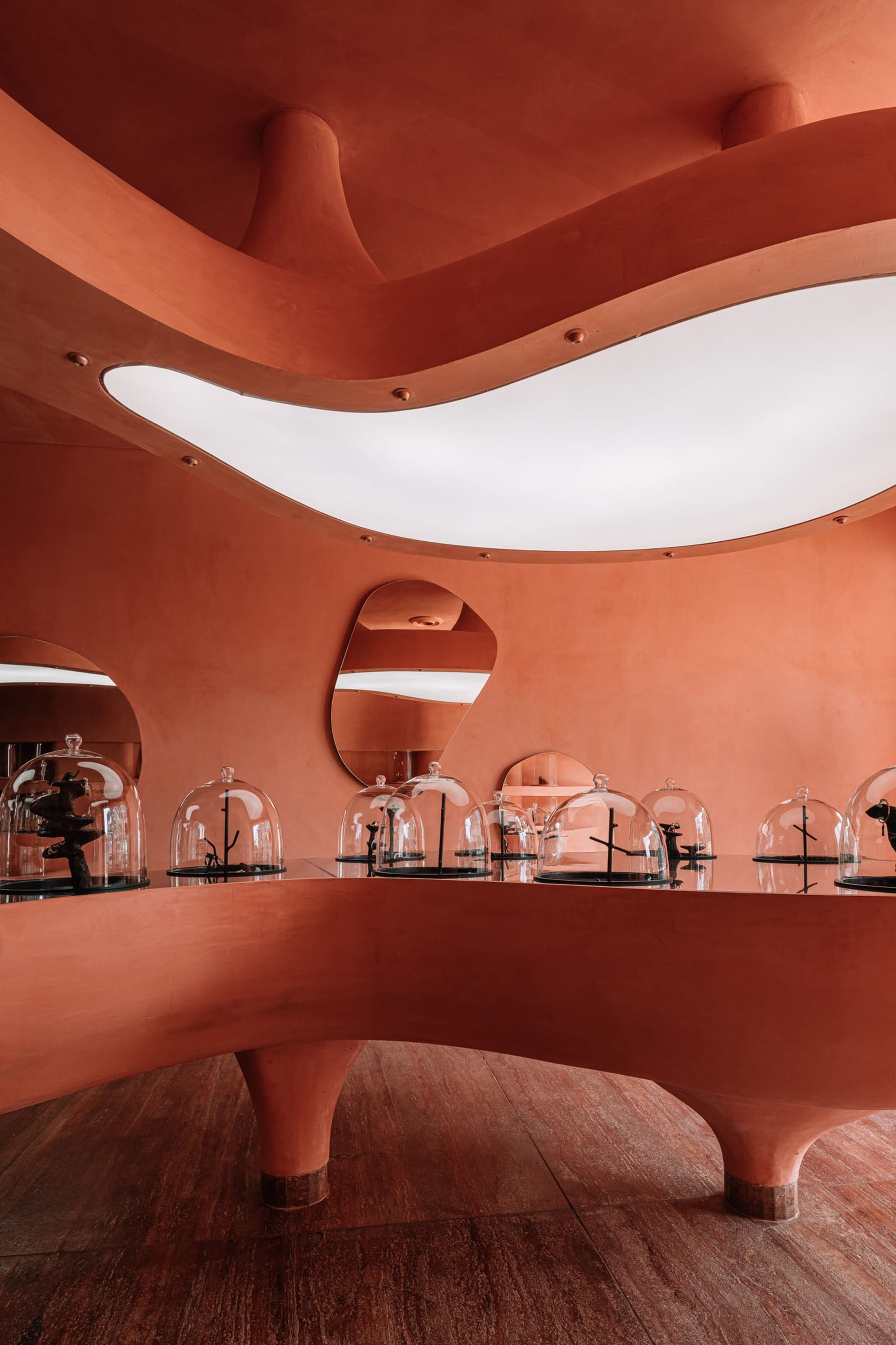 A modern art gallery featuring glass sculptures on display under glass domes.